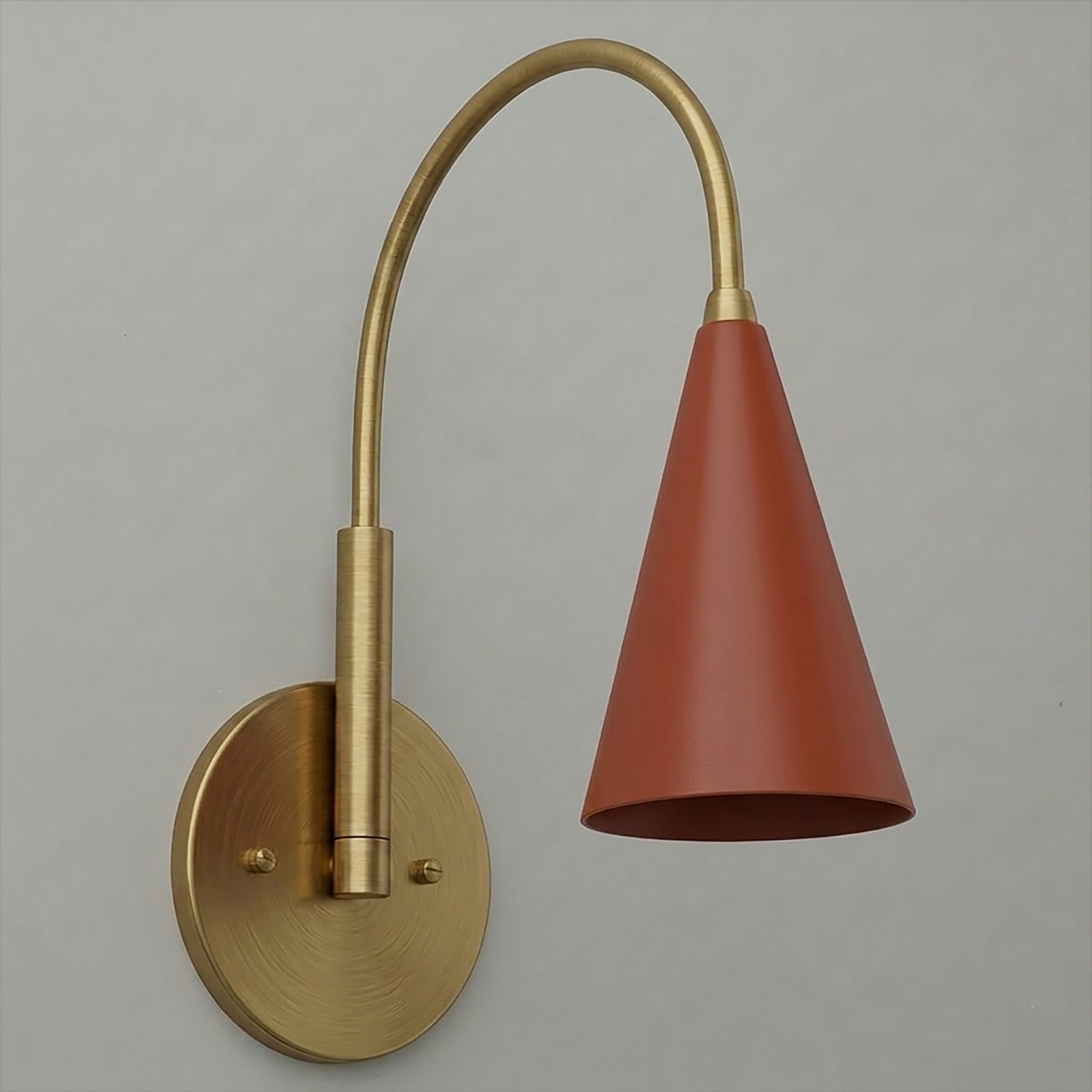 Wall sconce with brushed brass round base and curved arm holding a matte terracotta cone-shaped shade. - SCONCE MODEL NO. 1309