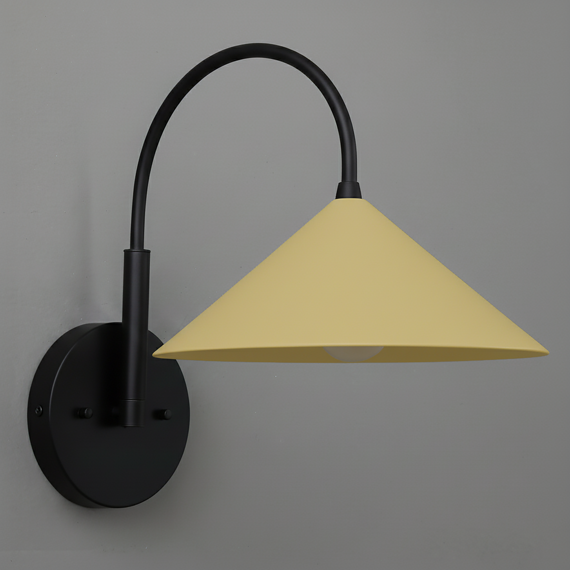 Black metal wall sconce with curved arm and soft yellow conical lampshade. - Sconce Model No. 1583