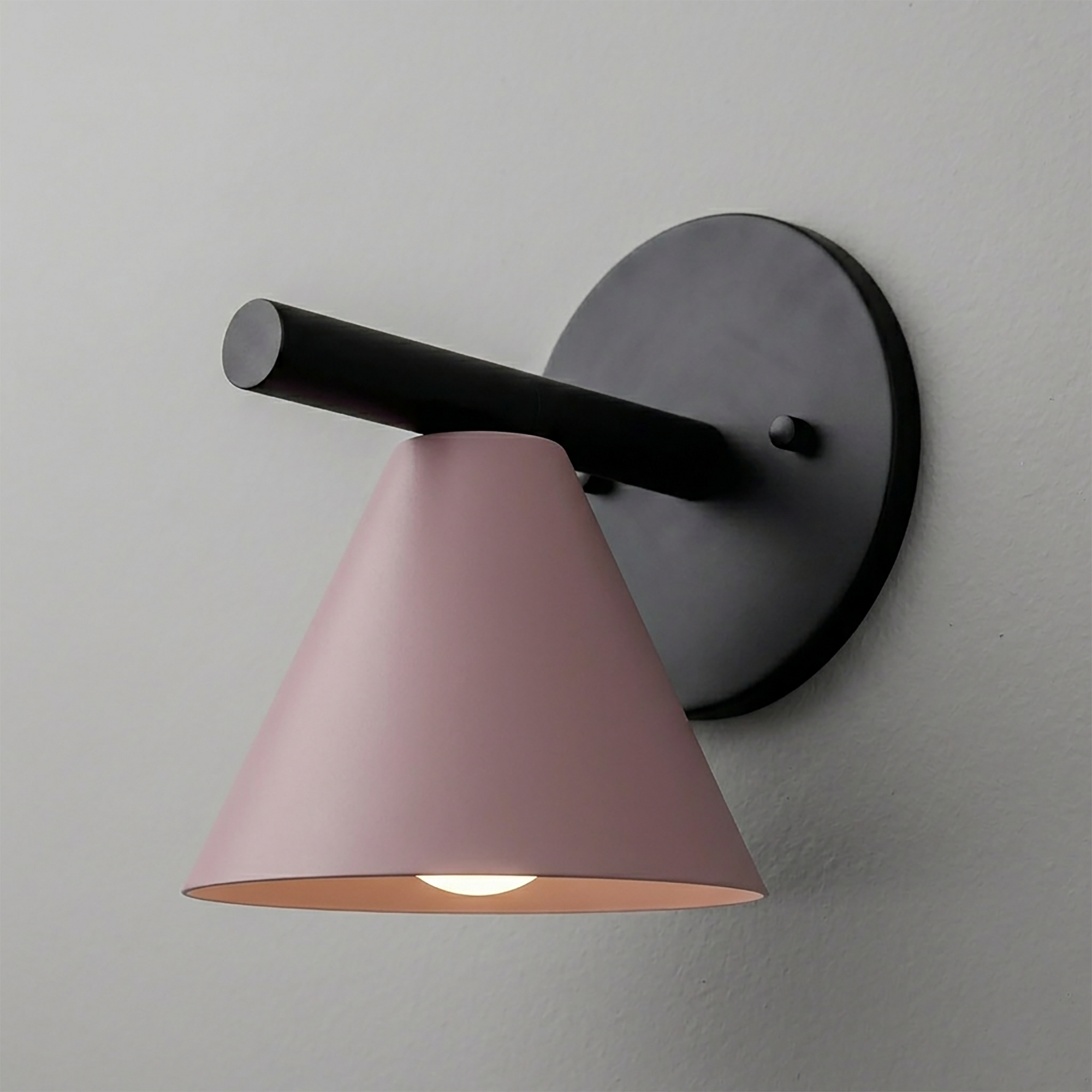 Wall-mounted sconce with matte black round base and arm, featuring a pink cone-shaped shade. - SCONCE MODEL NO. 5075