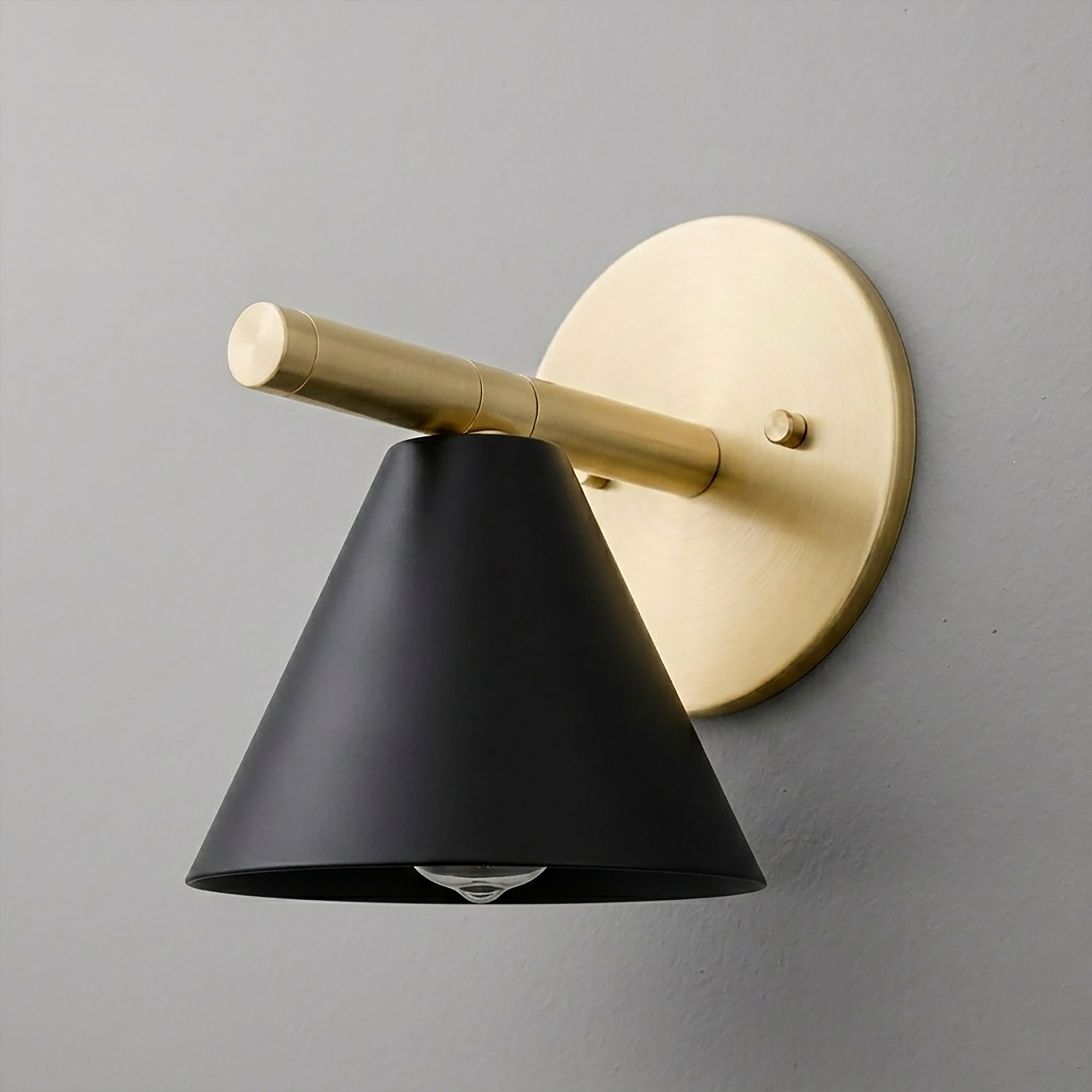 Wall sconce with brushed brass arm and round backplate, matte black conical shade, single bulb design. - SCONCE MODEL NO. 5075
