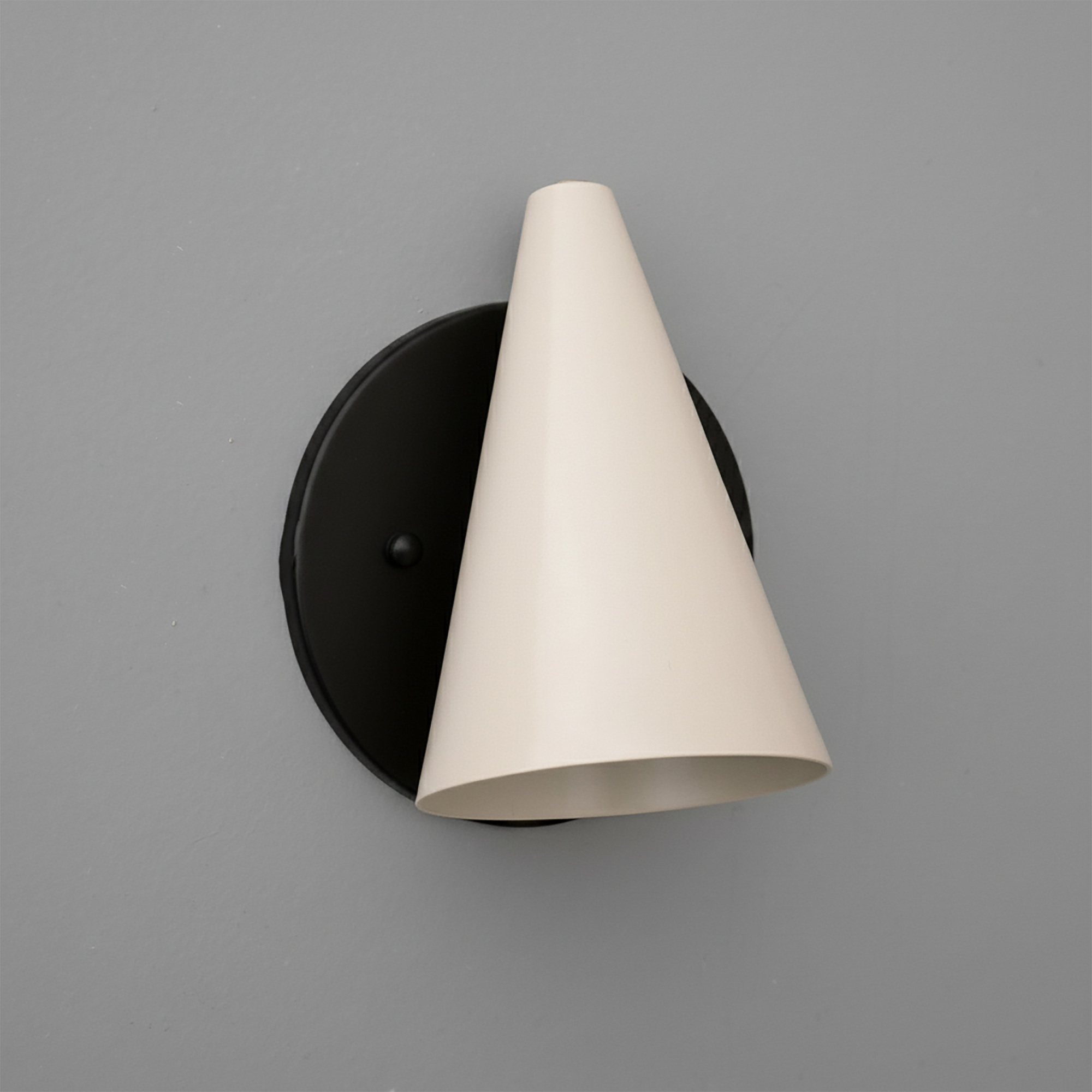 Matte black round wall base with a downward-facing cream-colored conical metal shade sconce. - SCONCE MODEL NO. 5950