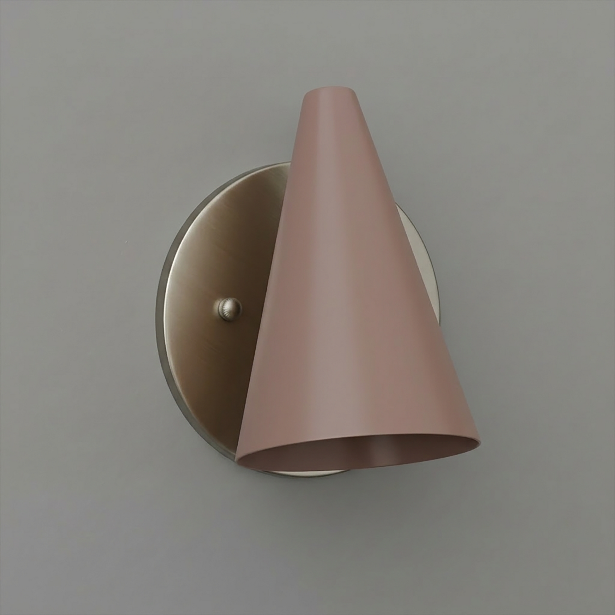 Matte pink metal cone-shaped wall sconce with brushed brass round backplate and single bulb fixture. - SCONCE MODEL NO. 5950
