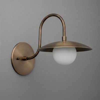 Antique brass wall sconce with curved arm, flat wide metal shade, and frosted globe bulb. - SCONCE MODEL NO. 3799