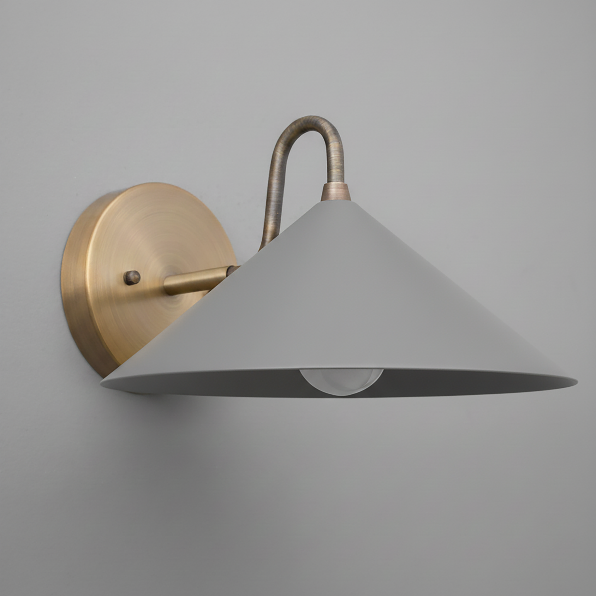 Wall sconce with matte gray conical shade and antique brass curved arm and round backplate. - SCONCE MODEL NO. 6528