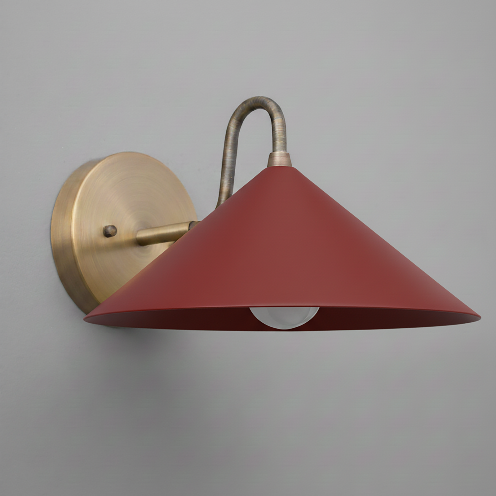 Wall sconce with antique brass mount and curved arm, featuring a wide brick red conical shade. - SCONCE MODEL NO. 6528