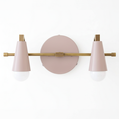Industrial-style vanity light with two conical pink metal shades and brass accents on a round pink wall plate. - VANITY LIGHT MODEL NO. 1229