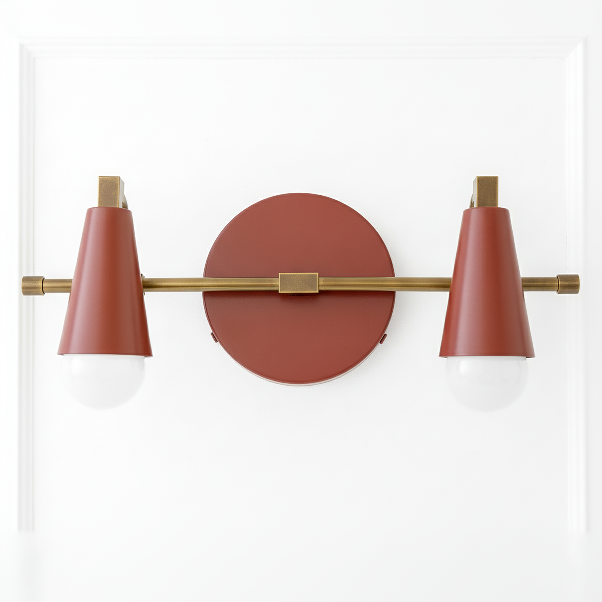 Industrial-style vanity light with two cone-shaped rust-colored shades on a horizontal brass rod and round wall mount. - VANITY LIGHT MODEL NO. 1229