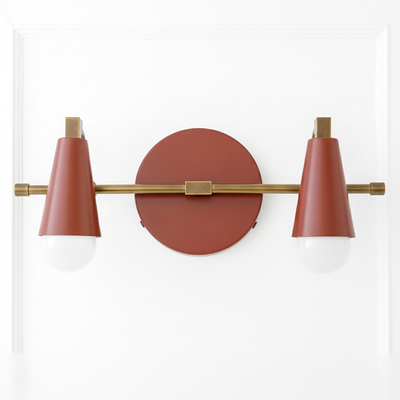 Industrial-style vanity light with two cone-shaped rust-colored shades on a horizontal brass rod and round wall mount. - VANITY LIGHT MODEL NO. 1229