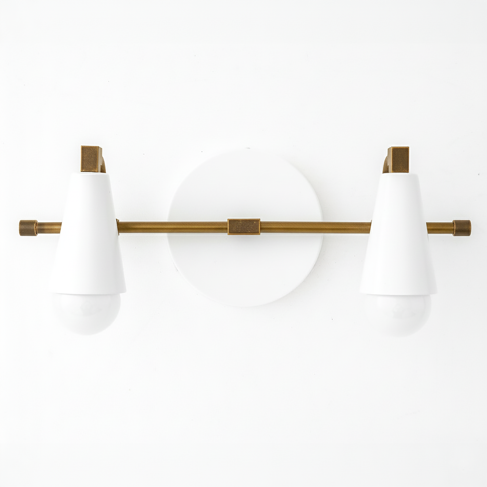 Two-bulb vanity light with white conical shades and antique brass horizontal rod and round white backplate. - VANITY LIGHT MODEL NO. 1229