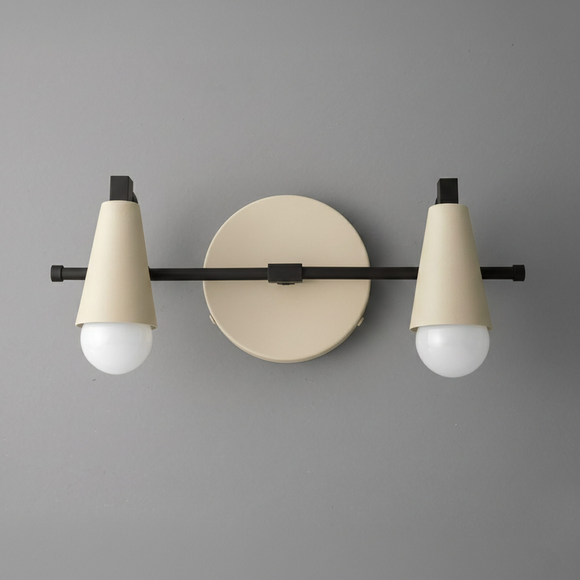 Two-light vanity fixture with black horizontal bar and beige conical shades over round beige wall mount. - VANITY LIGHT MODEL NO. 1229