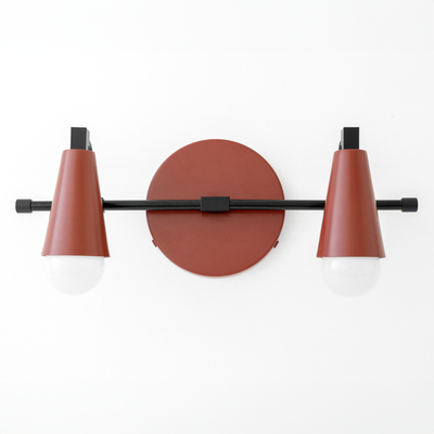 Industrial-style vanity light with two cone-shaped rust-colored shades and exposed white bulbs on a black horizontal bar. - VANITY LIGHT MODEL NO. 1229