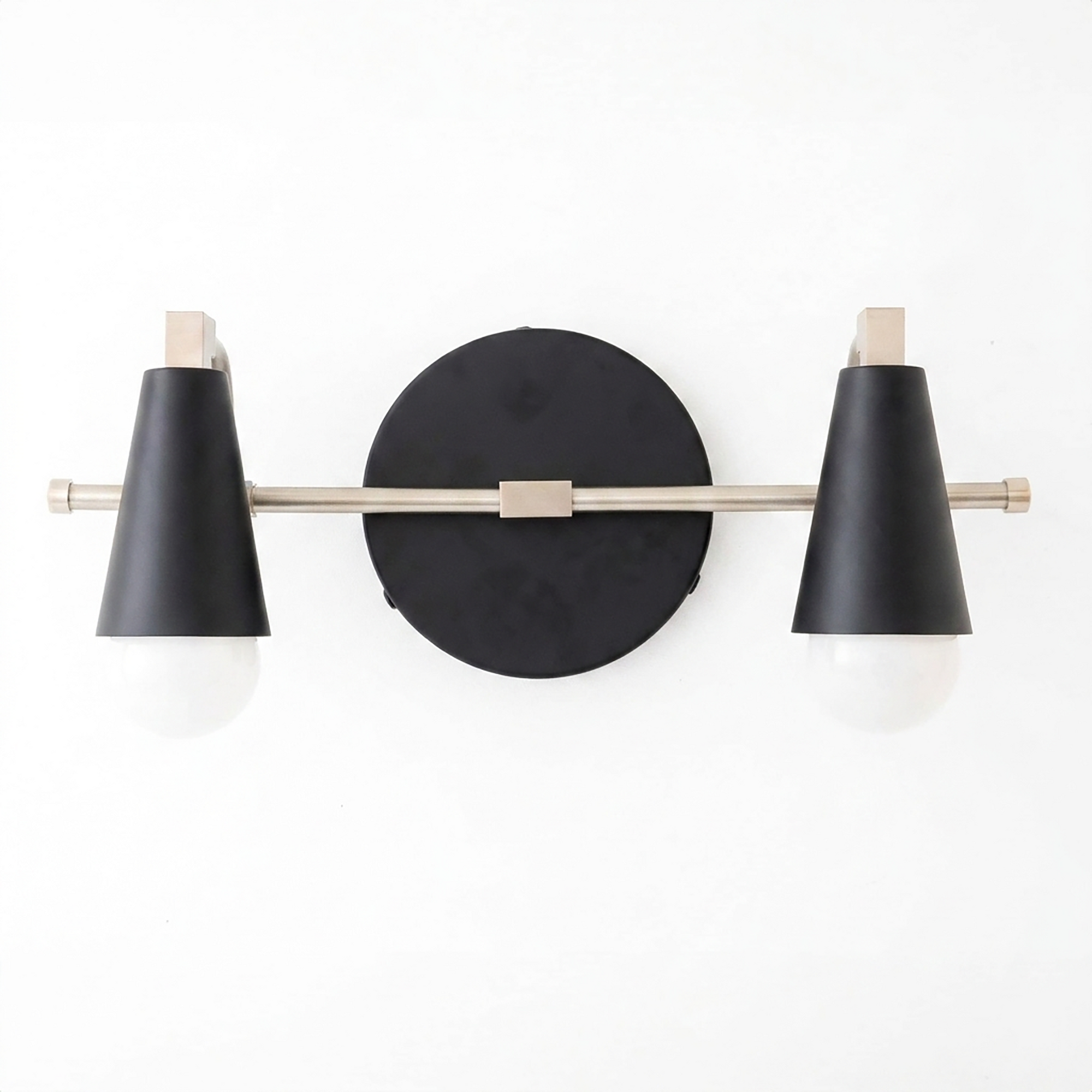 Scandinavian-style 2-bulb vanity light with black conical shades and brushed metal rod mounted on a round black base. - VANITY LIGHT MODEL NO. 1229