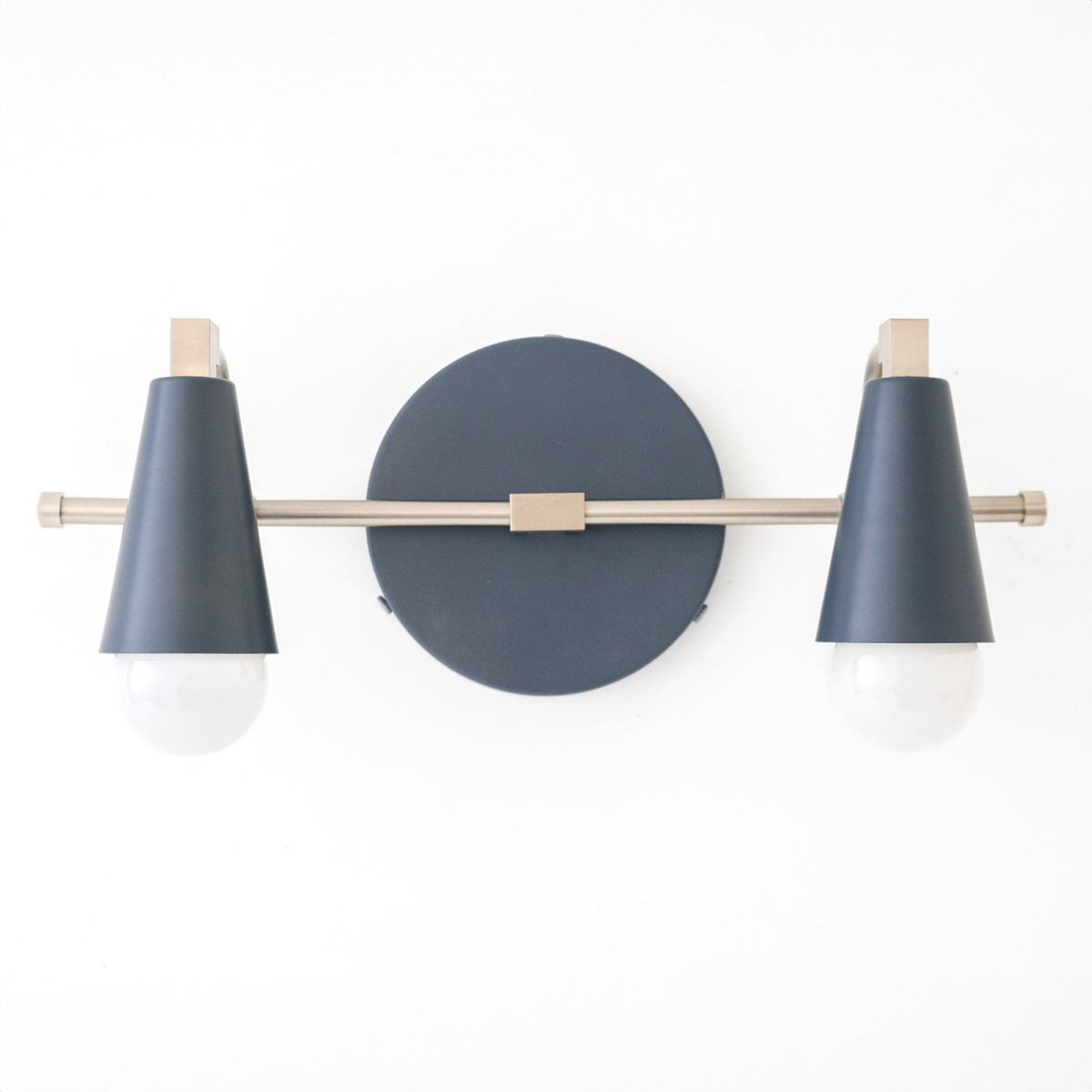 Industrial-style vanity light with two bare bulbs, black conical shades, and brass accents. - VANITY LIGHT MODEL NO. 1229