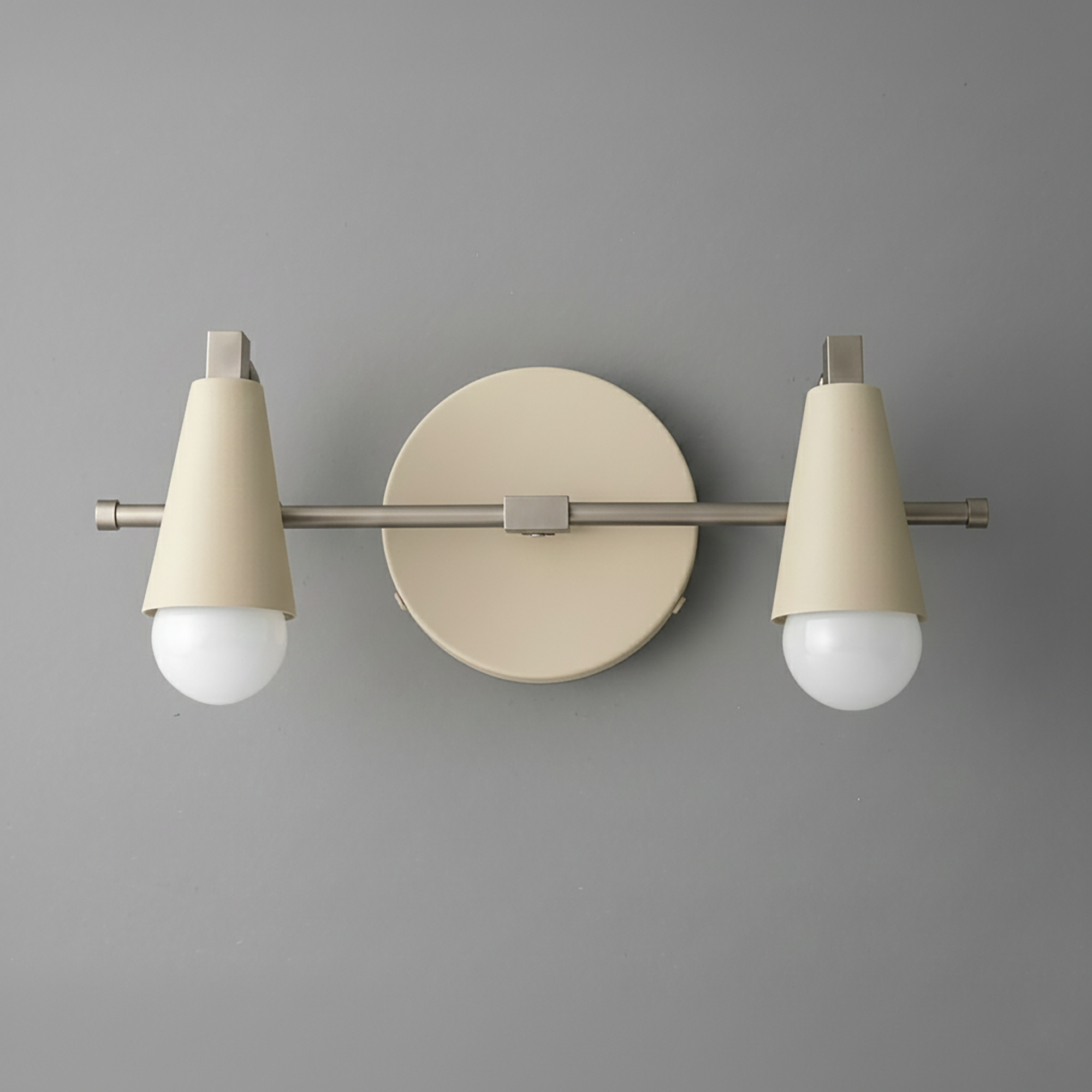 Industrial-style beige metal vanity light with two exposed round bulbs and a circular wall mount. - VANITY LIGHT MODEL NO. 1229