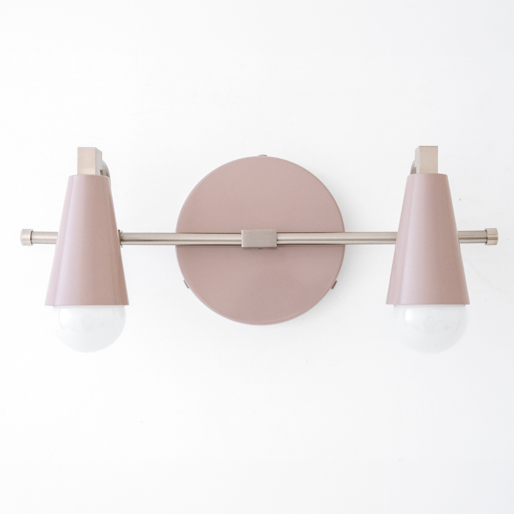 Scandinavian-style vanity light with two pink cone-shaped shades and exposed bulbs on a matte metal bar and round base. - VANITY LIGHT MODEL NO. 1229