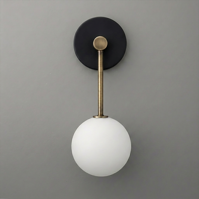 Wall sconce with matte black circular base, brass rod, and frosted white globe bulb shade. - Sconce Model No. 5999
