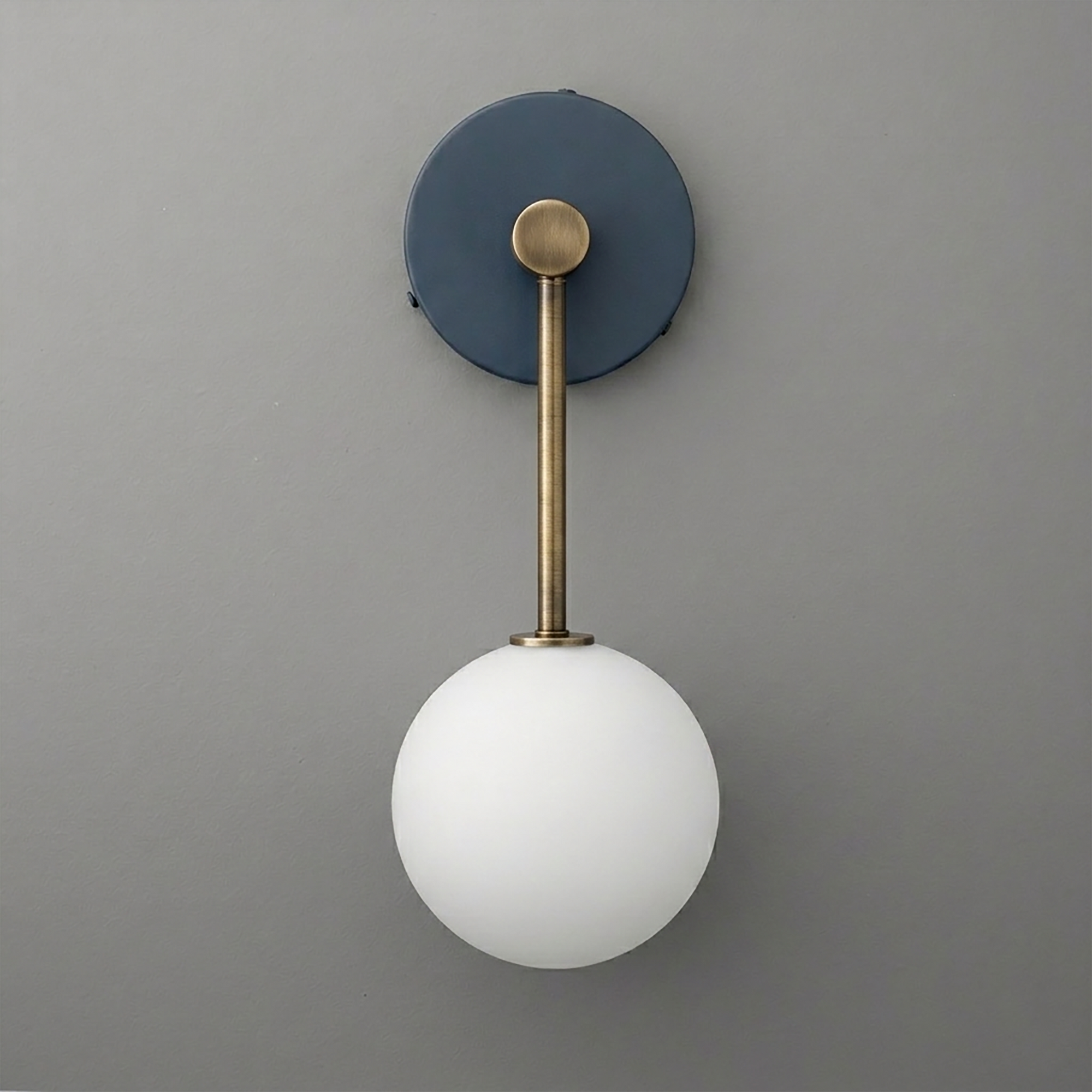 Wall sconce with matte black circular base, antique brass rod, and frosted white glass globe shade. - Sconce Model No. 5999