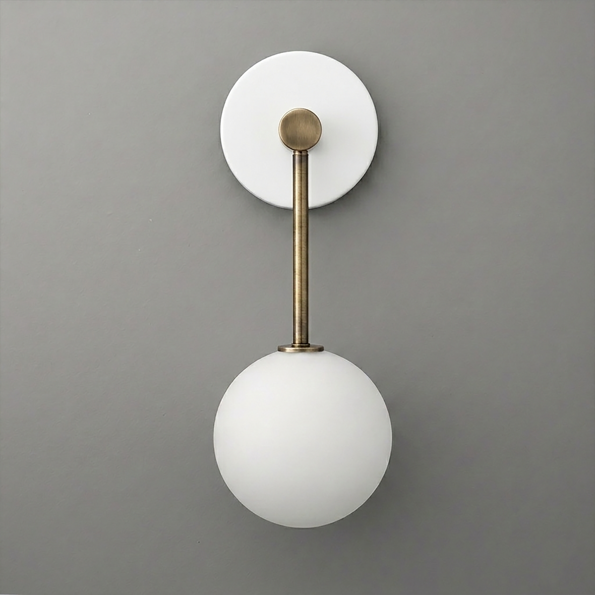 Wall sconce with matte white glass globe shade and brass-finished metal arm on round white backplate. - Sconce Model No. 5999
