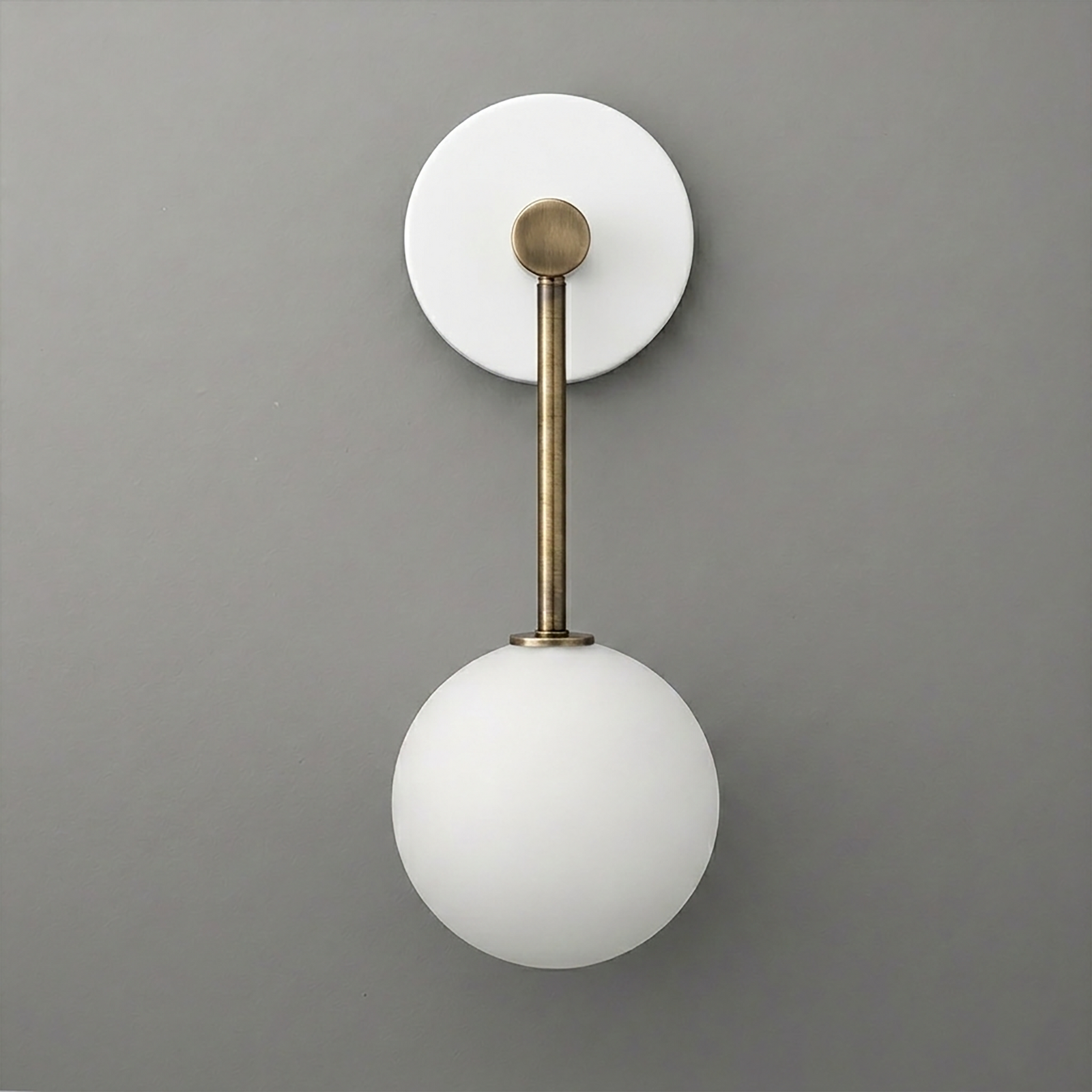 Wall sconce with matte white glass globe shade and brass-finished metal arm on round white backplate. - Sconce Model No. 5999