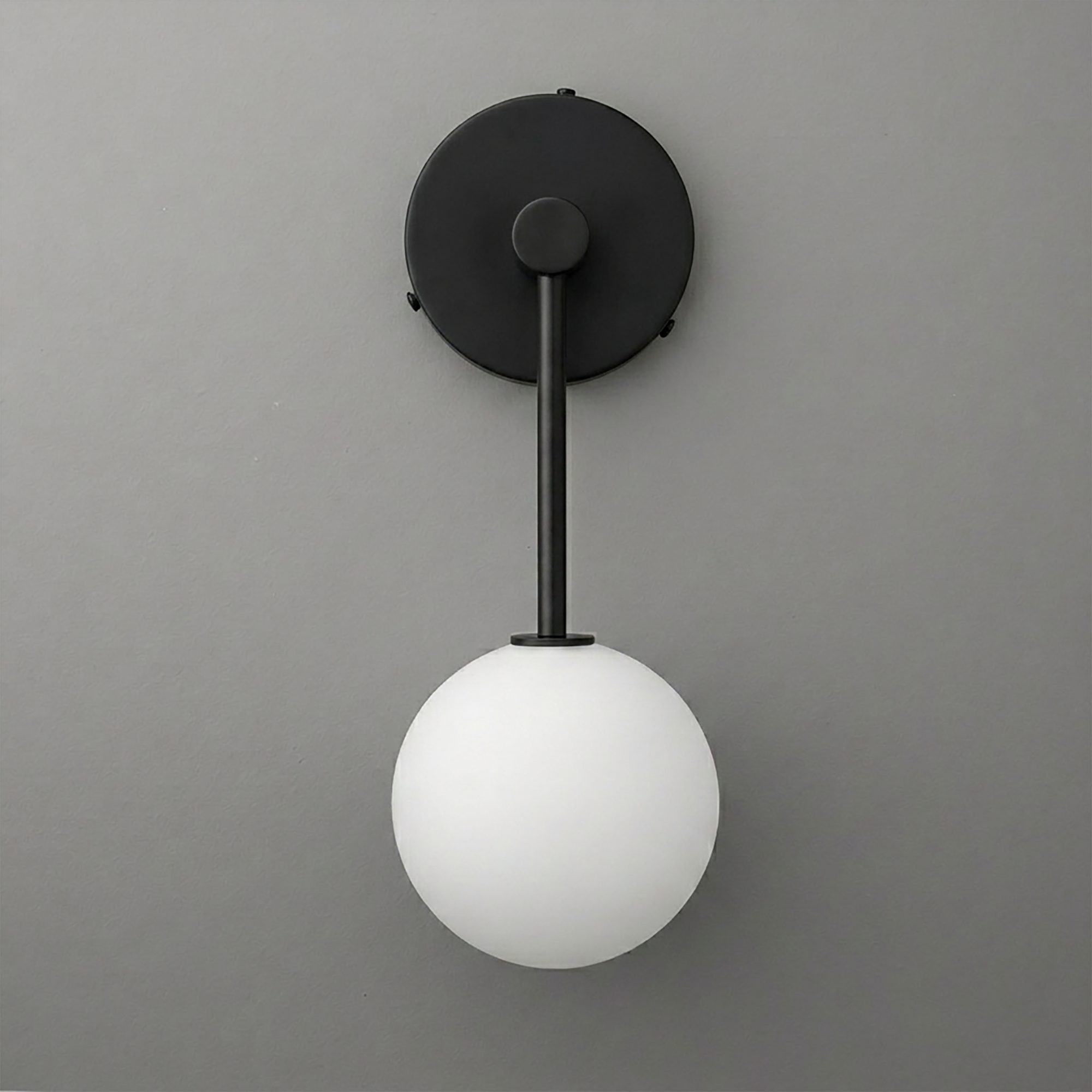 Black metal wall sconce with matte finish and single frosted white glass globe light shade. - Sconce Model No. 5999