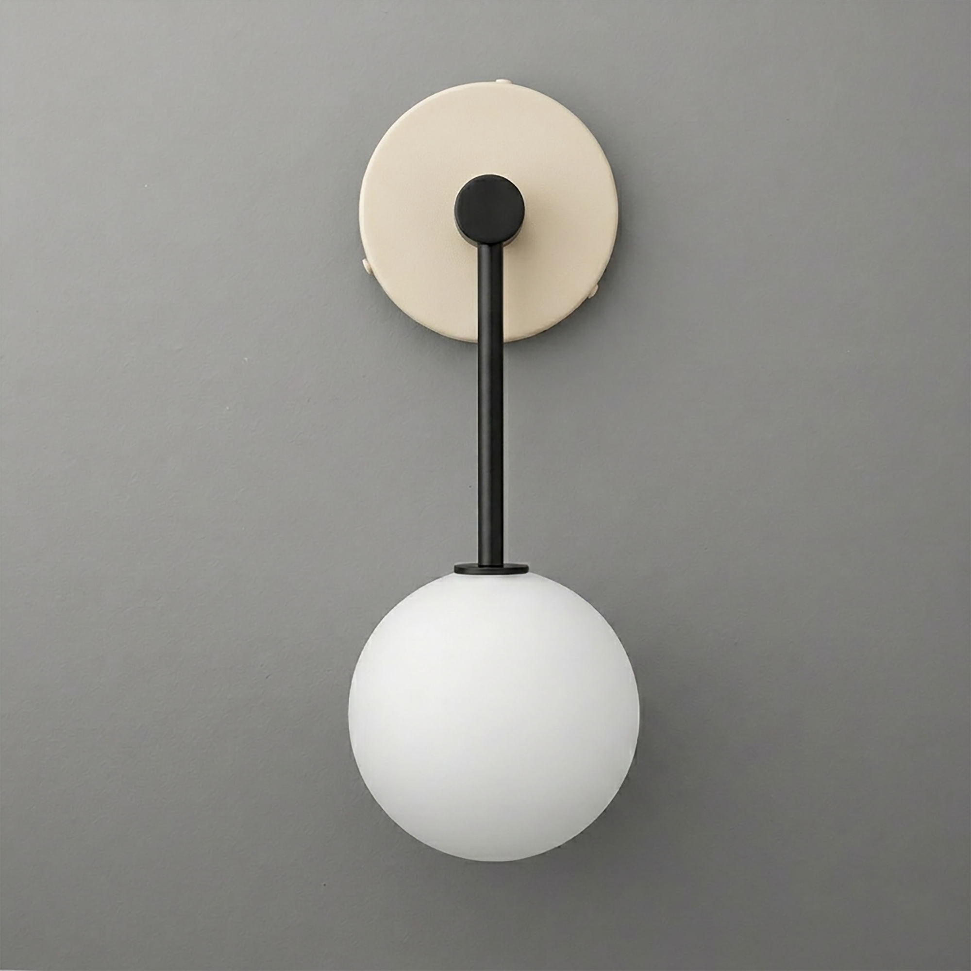 Wall sconce with matte black metal rod and frosted white glass globe shade on beige circular mount. - Sconce Model No. 5999