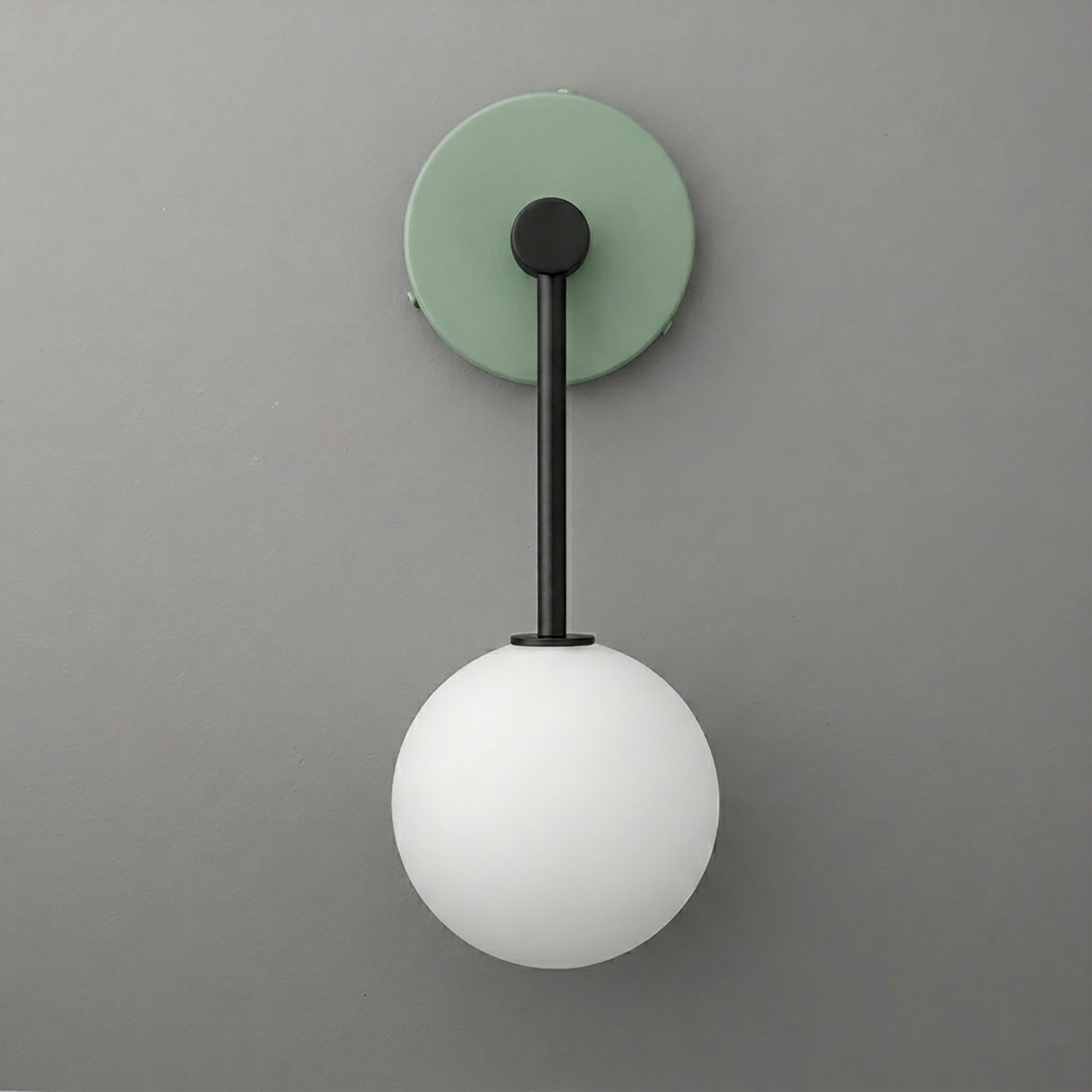Wall sconce with matte black metal arm, green circular backplate, and white frosted glass globe shade. - Sconce Model No. 5999
