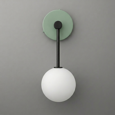 Wall sconce with matte black metal arm, green circular backplate, and white frosted glass globe shade. - Sconce Model No. 5999