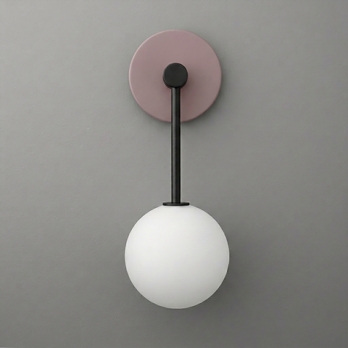 Wall sconce with a matte black arm, muted lavender round backplate, and frosted white glass globe shade. - Sconce Model No. 5999