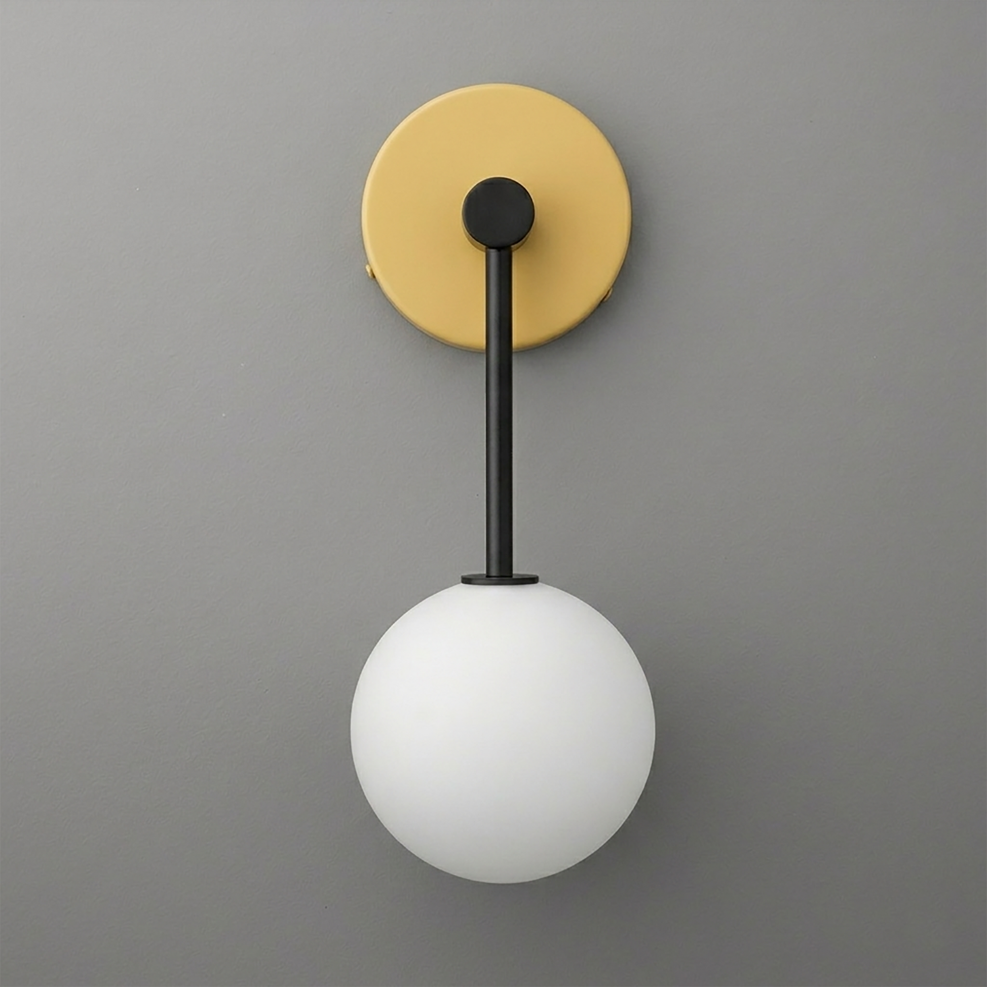 Matte black metal sconce with round brass backplate and white frosted glass globe shade. - Sconce Model No. 5999