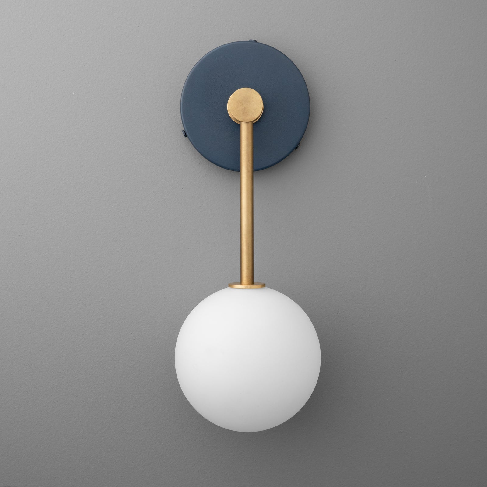 Wall sconce with matte black round base, brass rod, and white frosted glass globe shade. - Sconce Model No. 5999
