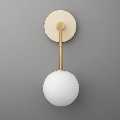 Wall sconce with a matte gold metal arm and round white frosted glass globe shade on a circular backplate. - Sconce Model No. 5999