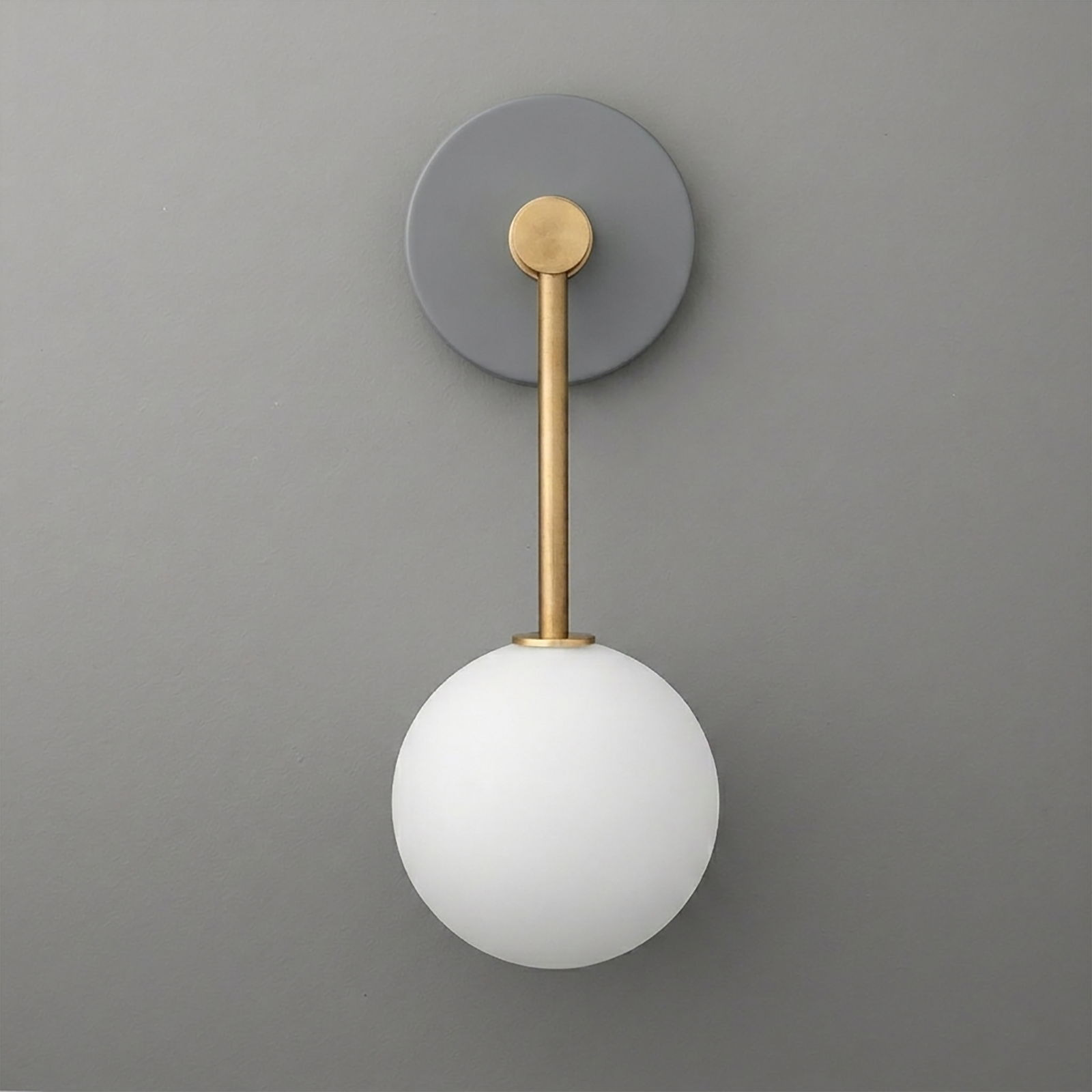Modern wall sconce with matte gray round base, brass arm, and frosted white glass globe shade. - Sconce Model No. 5999