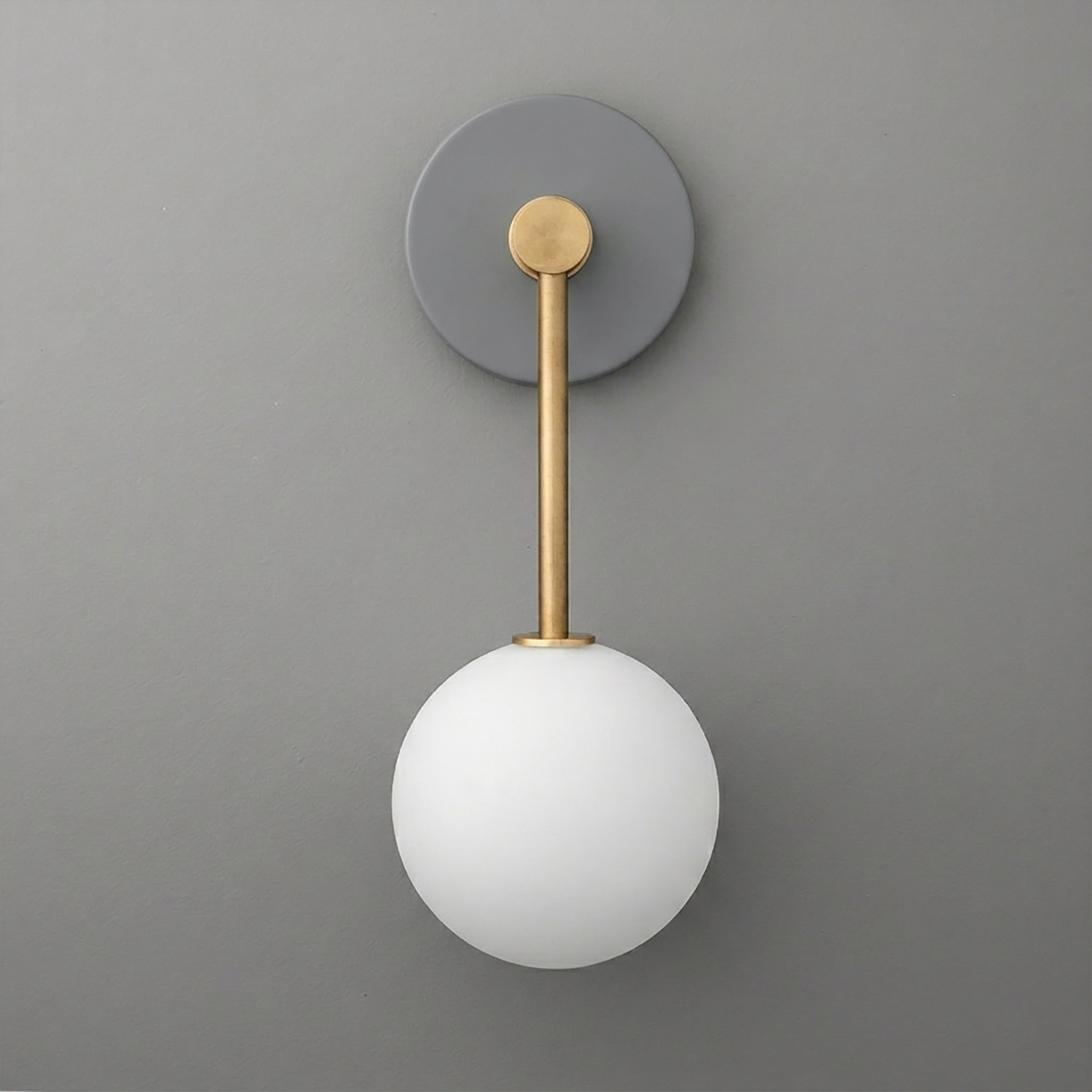 Modern wall sconce with matte gray round base, brass arm, and frosted white glass globe shade. - Sconce Model No. 5999