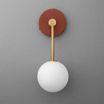 Wall sconce with matte white glass globe, brass rod, and round rust-colored metal base. - Sconce Model No. 5999