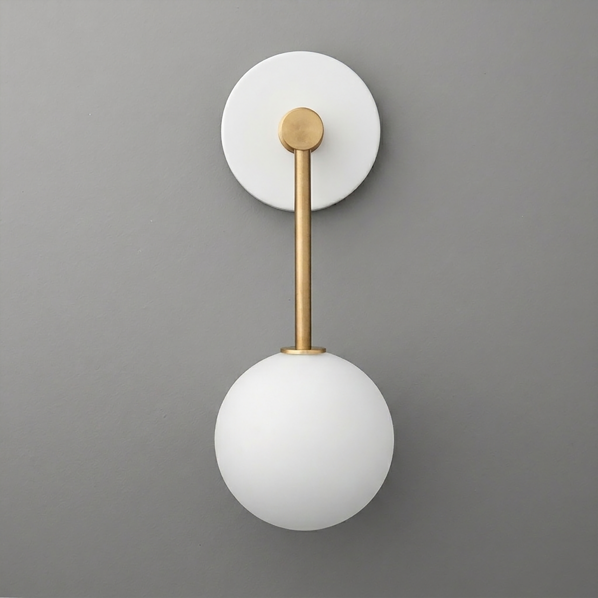 Wall sconce with matte white round backplate, brass rod, and frosted white glass globe shade. - Sconce Model No. 5999