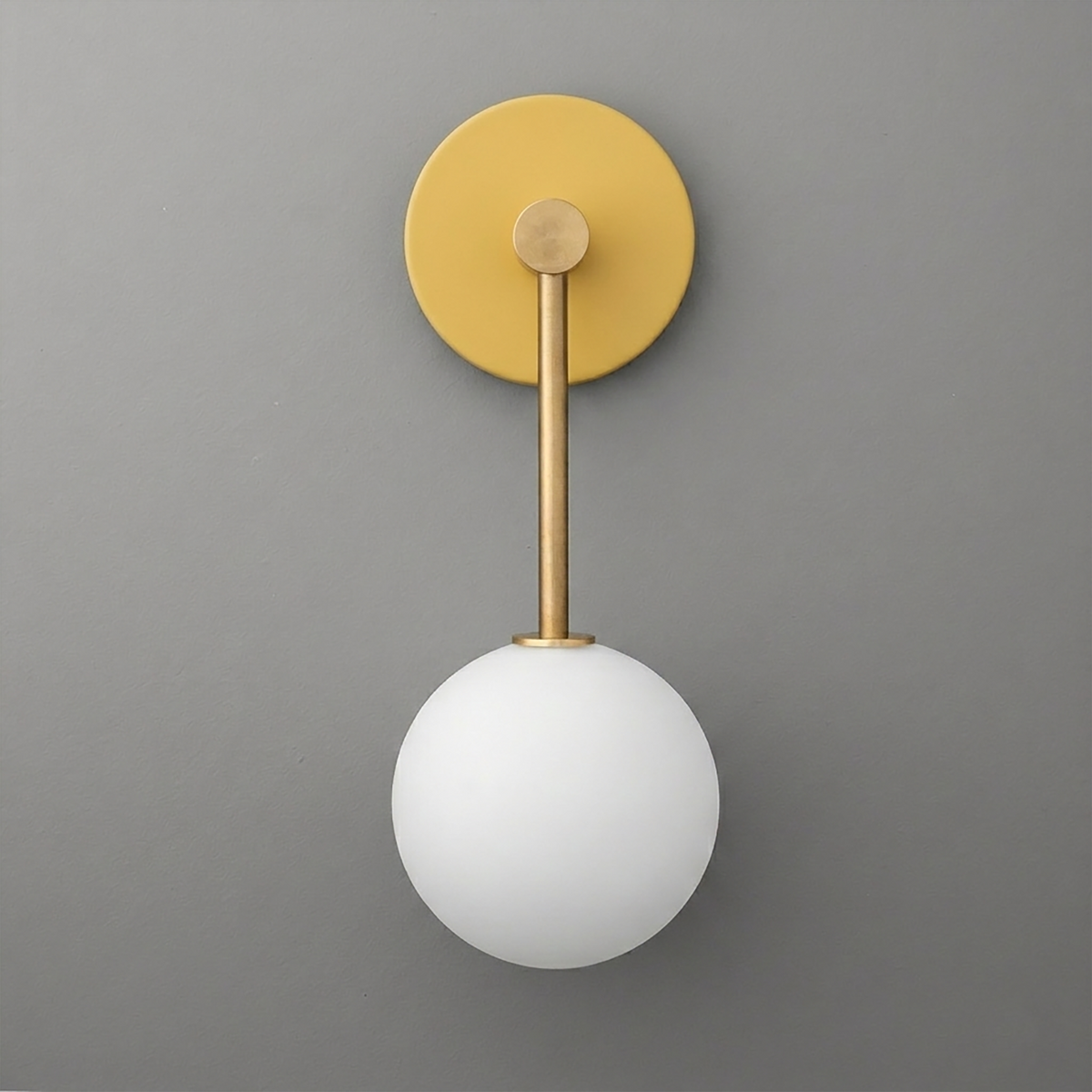 Matte gold wall sconce with a round backplate and white frosted glass globe shade. - Sconce Model No. 5999
