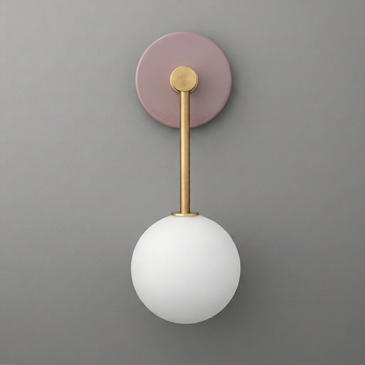Wall sconce with a round matte mauve base, brass rod, and frosted white glass globe shade. - Sconce Model No. 5999
