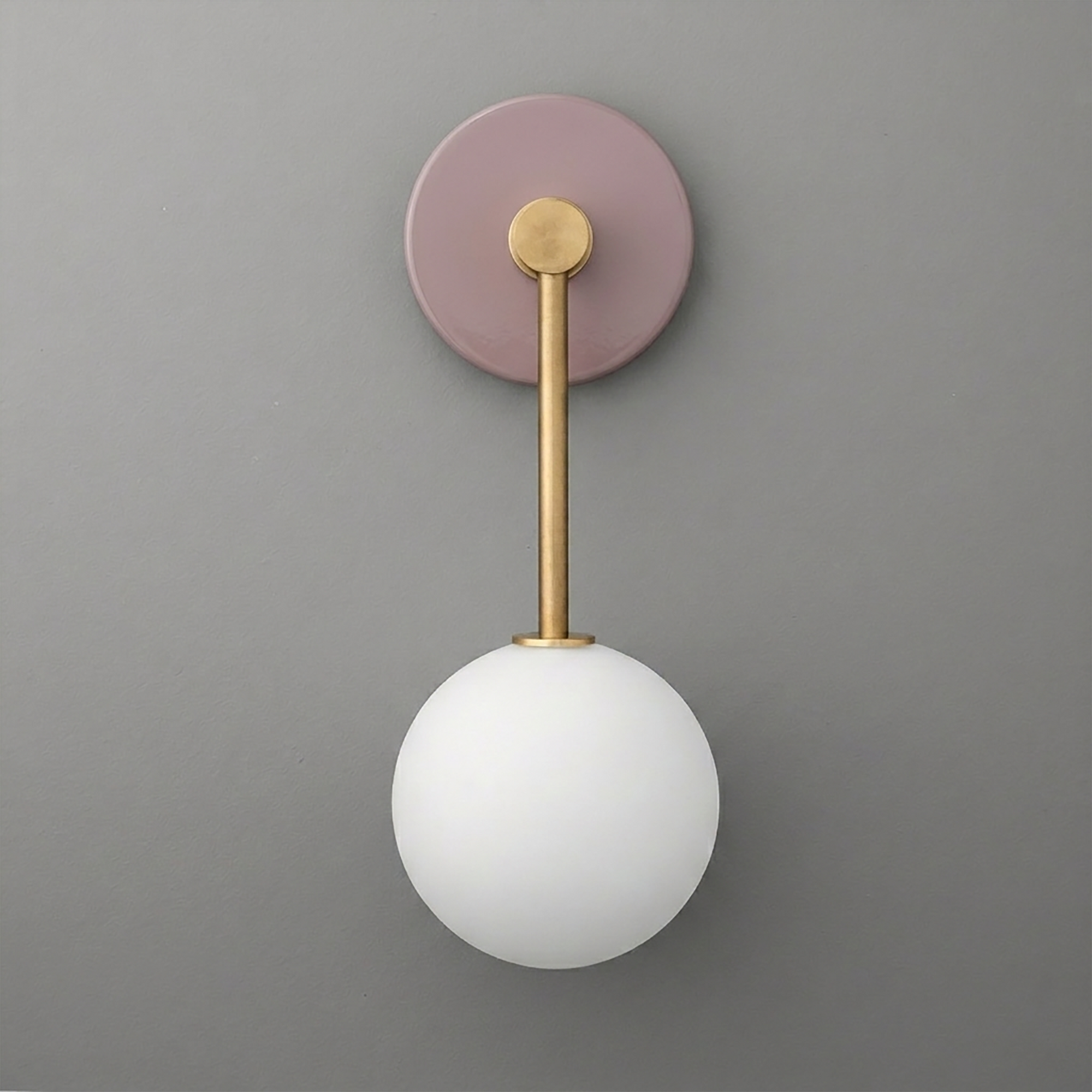 Wall sconce with a round matte mauve base, brass rod, and frosted white glass globe shade. - Sconce Model No. 5999