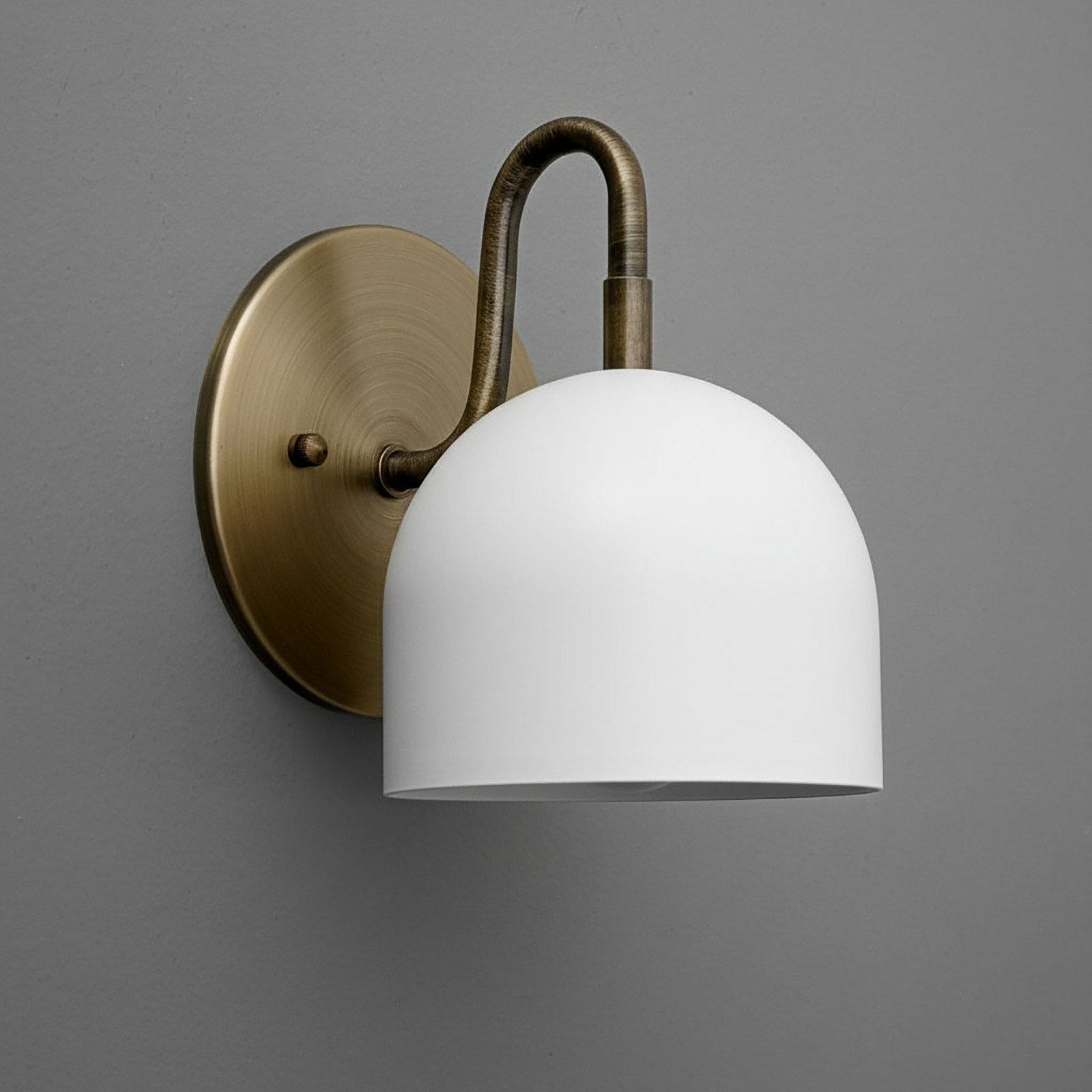 Wall-mounted sconce with matte white dome shade and aged brass curved arm and round backplate. - Sconce Model No. 5416