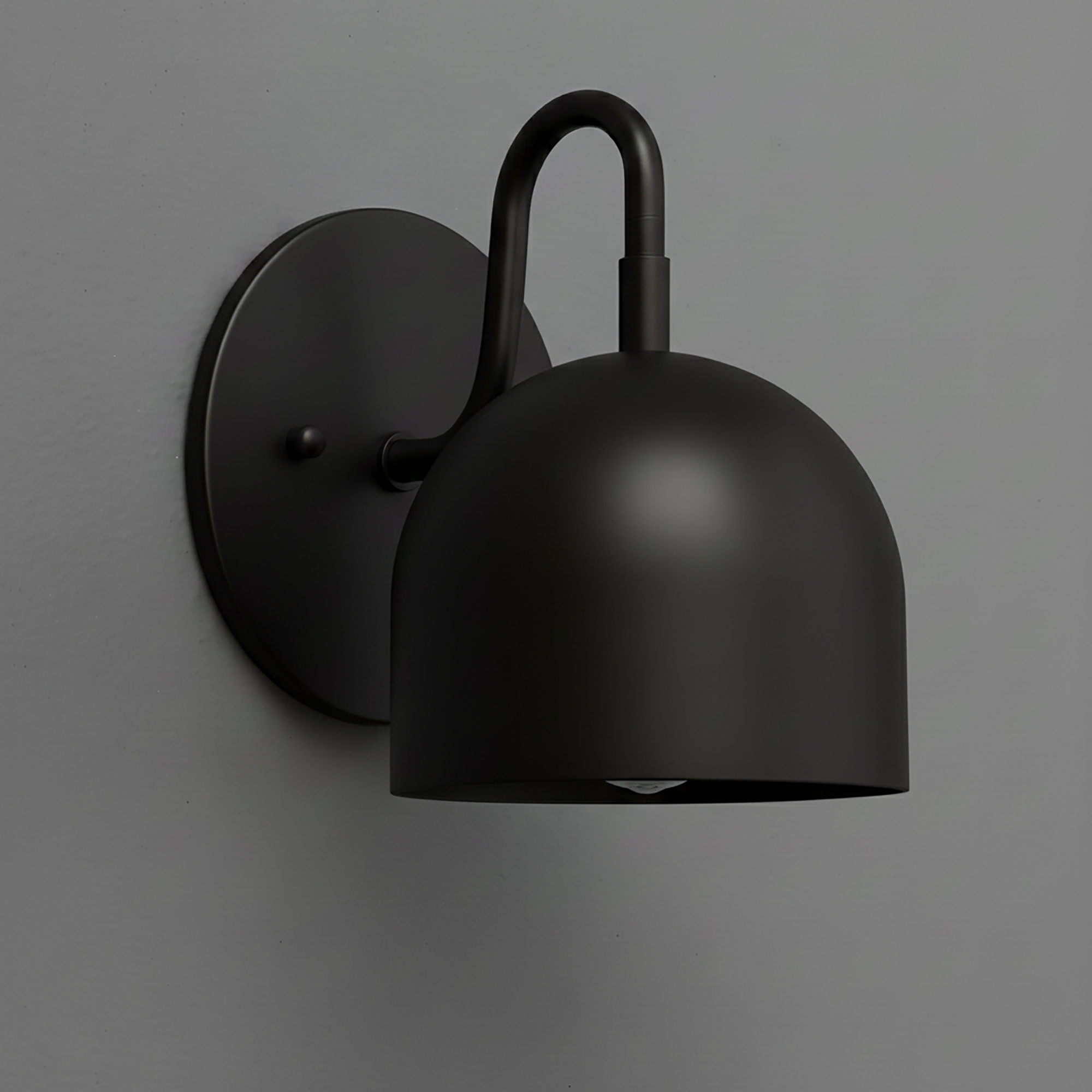 Matte black metal wall sconce with dome-shaped shade and curved arm mounting on round backplate. - Sconce Model No. 5416
