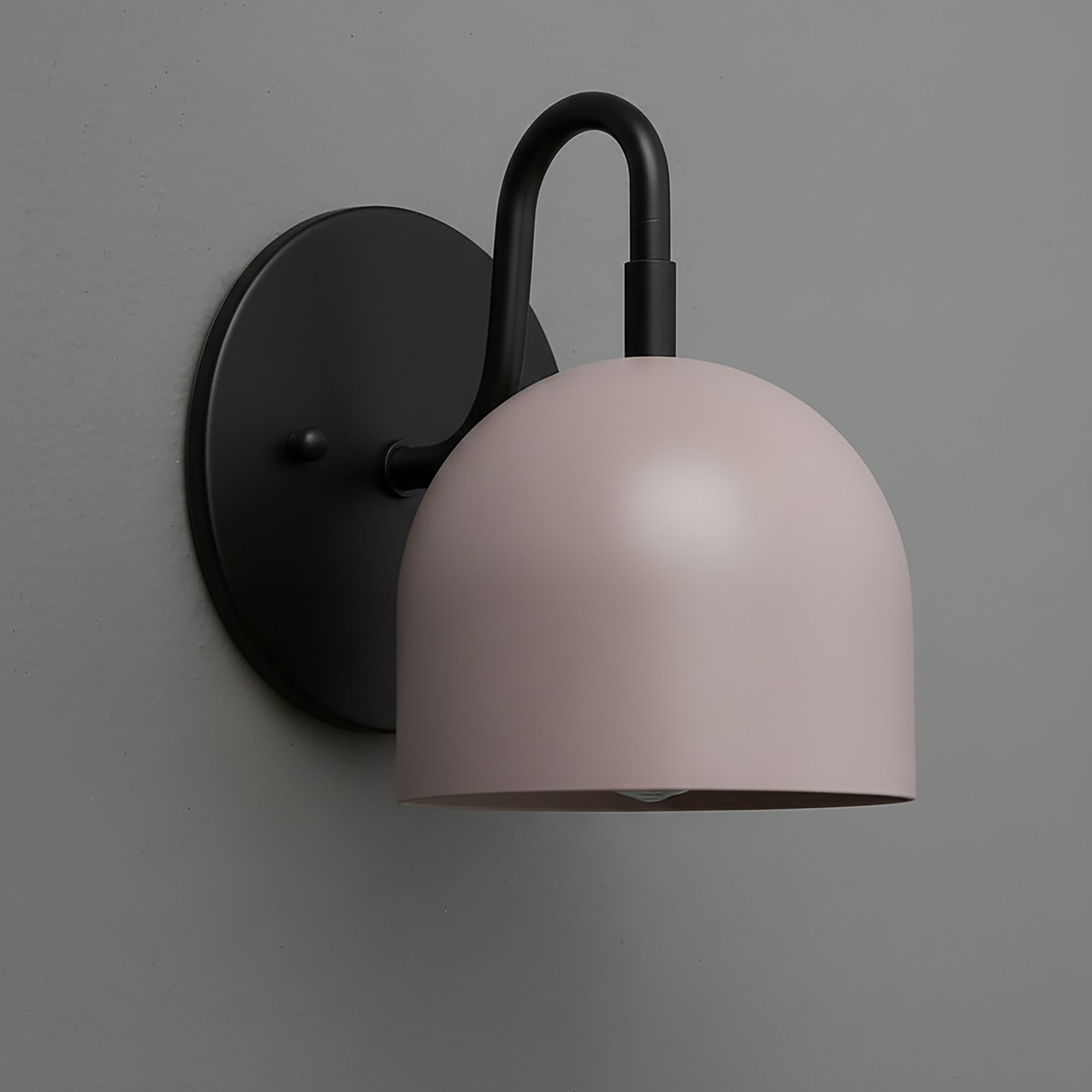 Matte black wall sconce with a smooth, dome-shaped pale pink shade and curved arm mount. - Sconce Model No. 5416