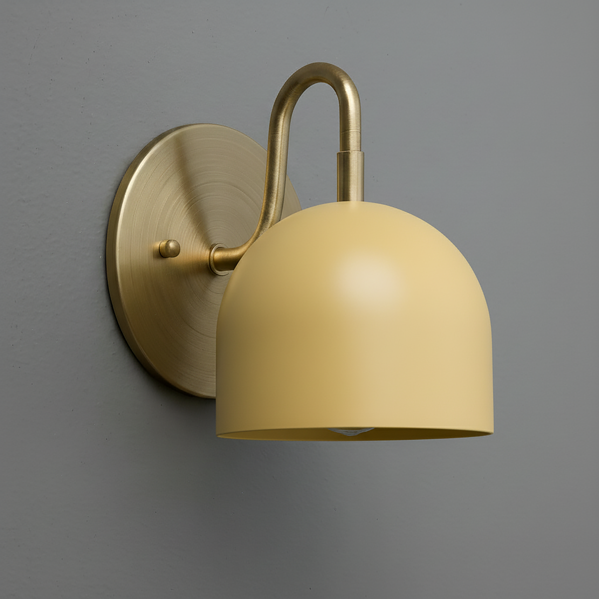 Antique brass sconce with smooth matte yellow dome shade mounted on round backplate. - Sconce Model No. 5416