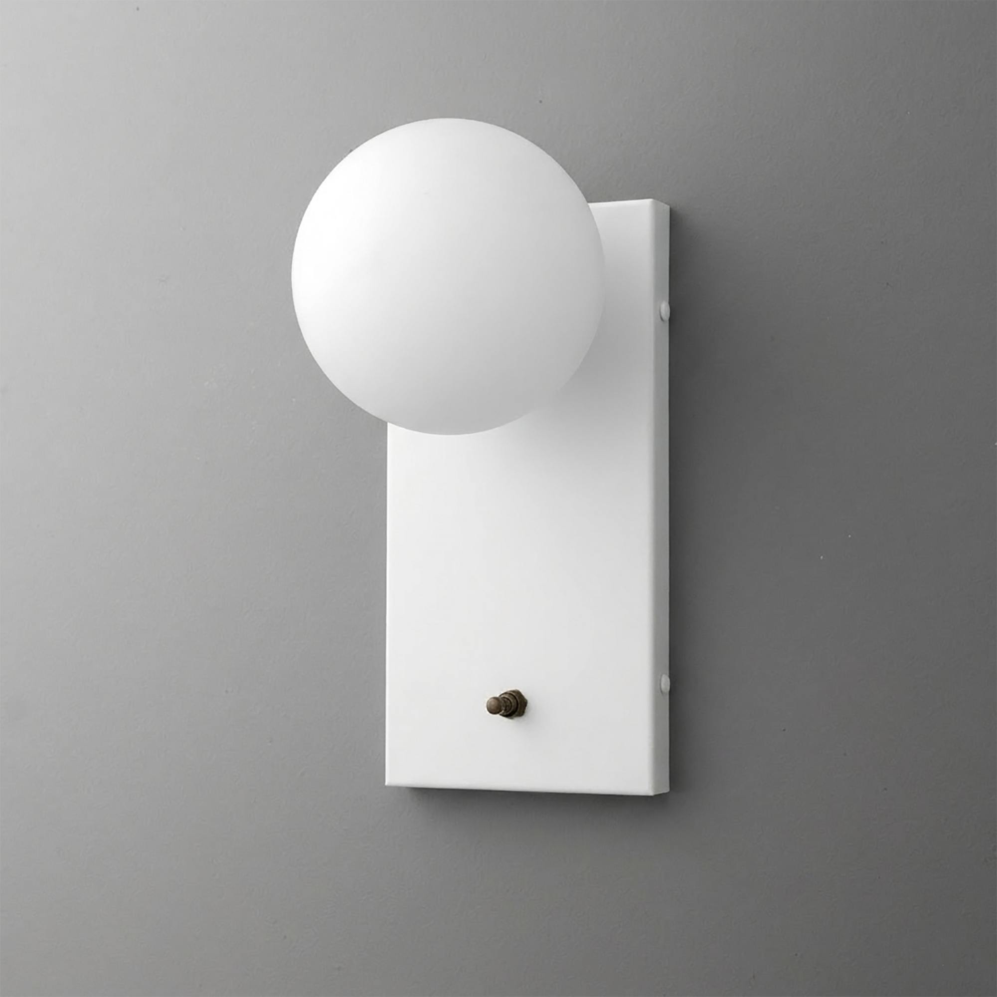 White rectangular metal backplate sconce with matte white globe-shaped bulb cover and small brass toggle switch. - Sconce Model No. 2196