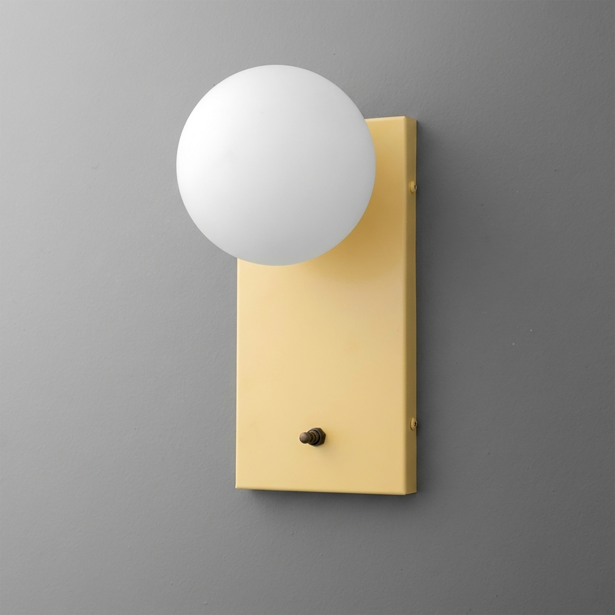Wall-mounted sconce with a matte gold rectangular backplate and a frosted white glass globe shade. - Sconce Model No. 2196