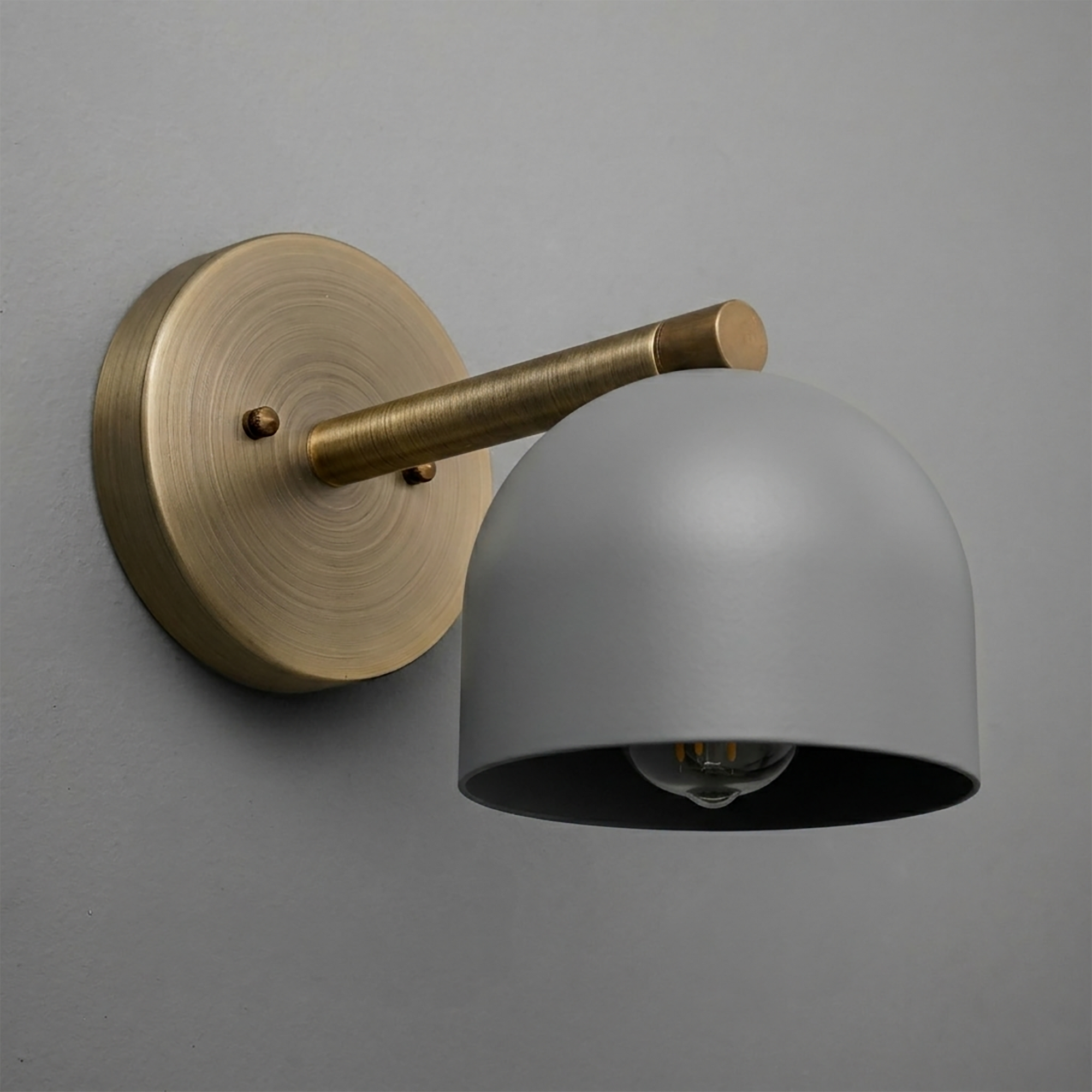 Brushed brass wall sconce with a matte gray dome-shaped shade and exposed bulb inside. - Sconce Model No. 5356