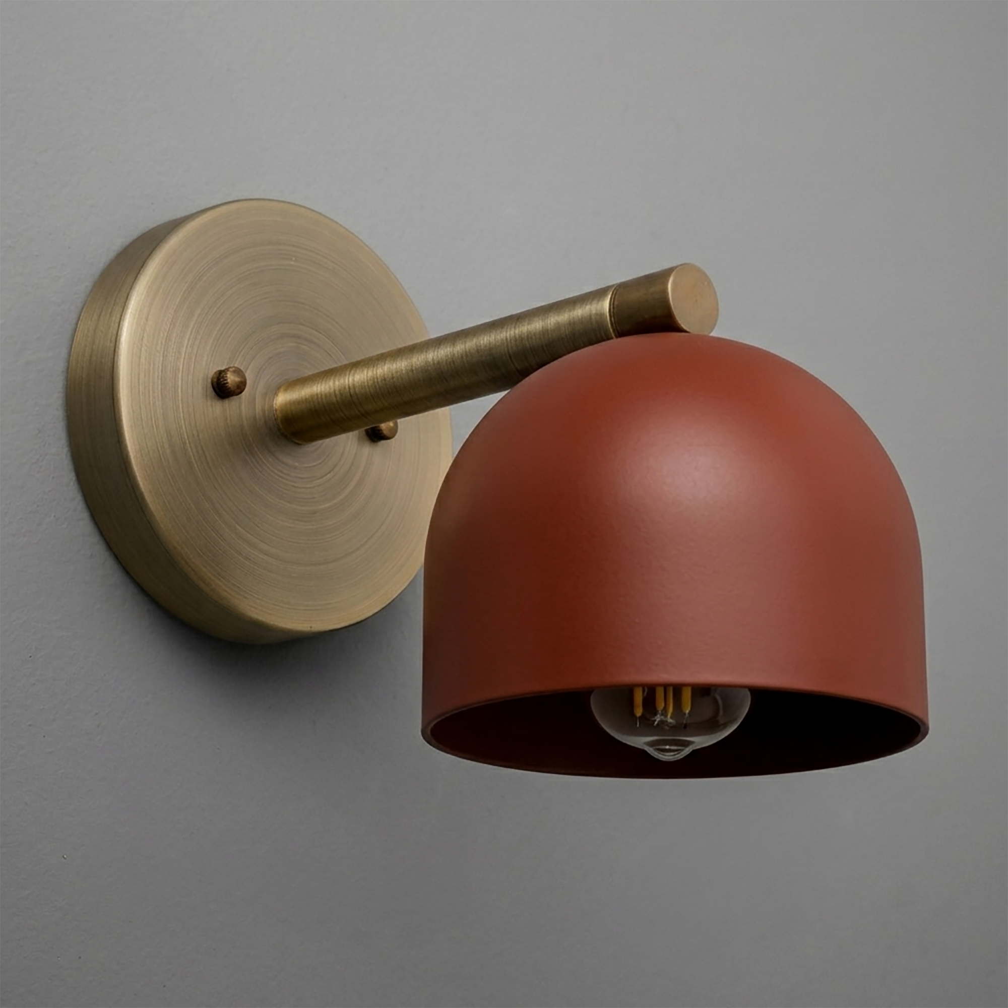 Wall sconce with matte rust red dome shade and brushed brass circular base and arm. - Sconce Model No. 5356
