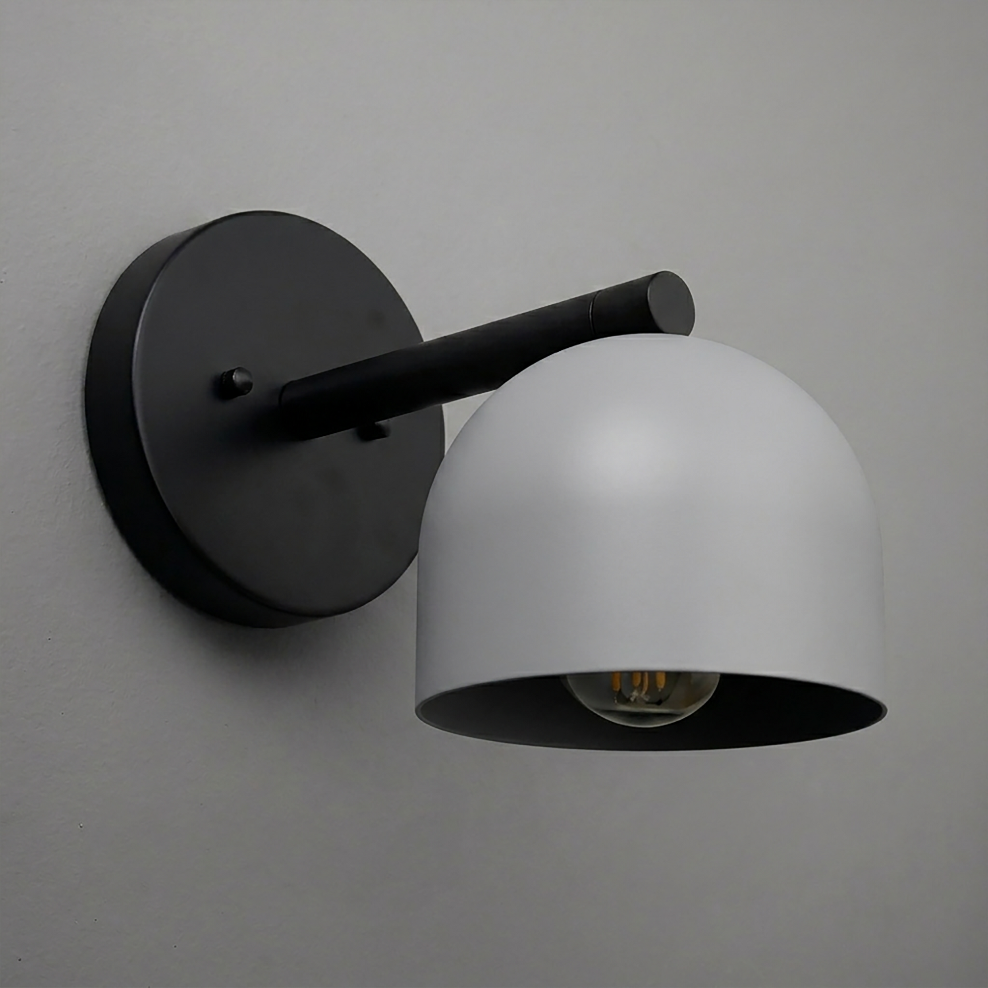 Black metal wall sconce with dome-shaped frosted white glass shade and single exposed bulb. - Sconce Model No. 5356