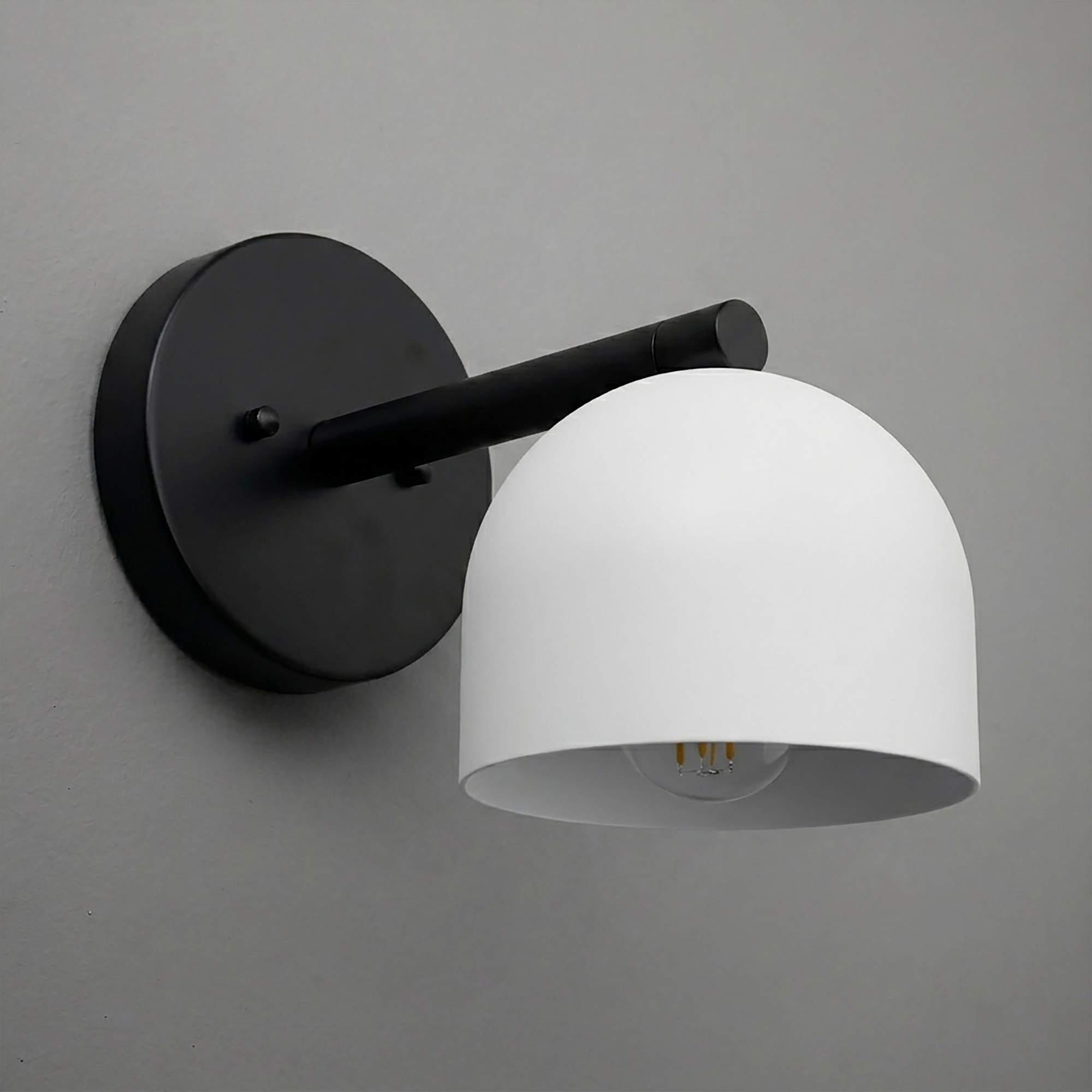 Matte black wall sconce with a curved arm and a smooth white dome-shaped shade. - Sconce Model No. 5356