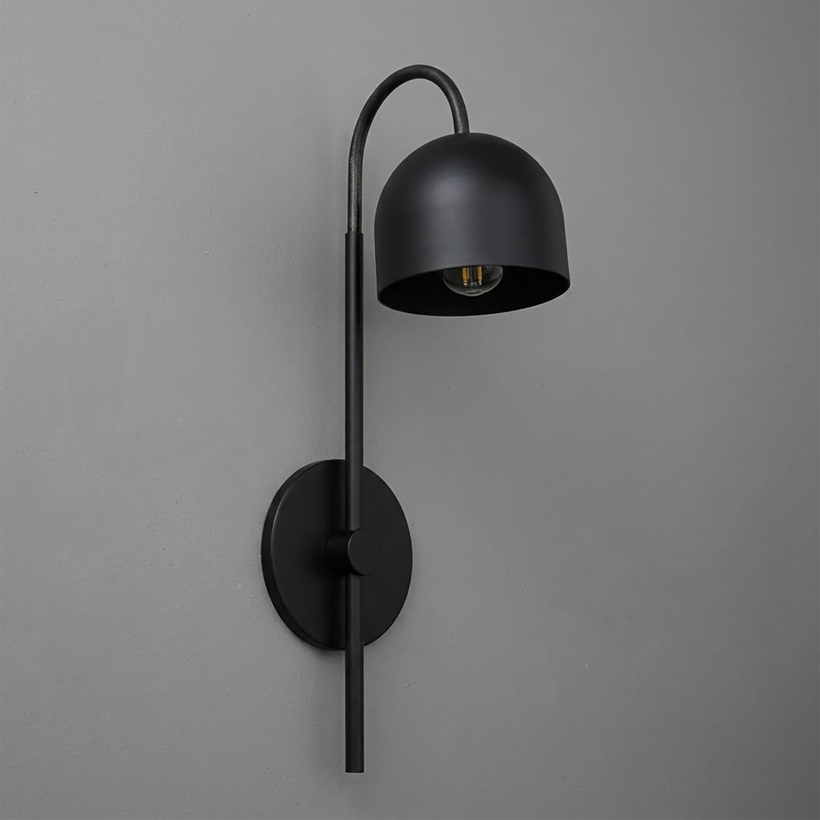 Matte black metal wall sconce with curved arm and dome-shaped shade, single bulb design. - Sconce Model No. 7340