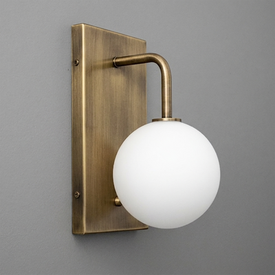 Wall sconce with antique brass rectangular backplate and curved arm holding a white frosted glass globe bulb. - SCONCE MODEL NO. 9002
